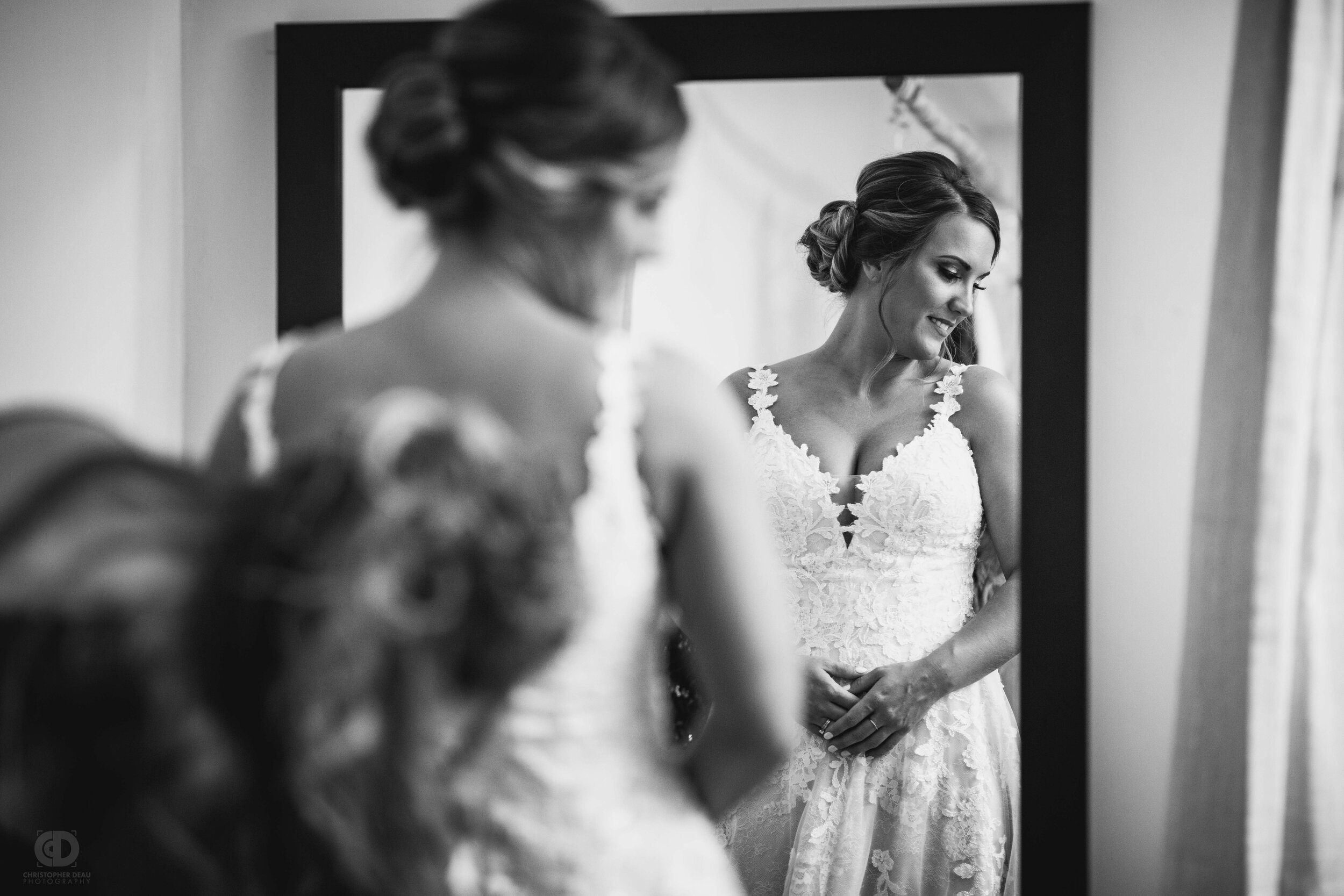  bride getting buttoned up by her mother 