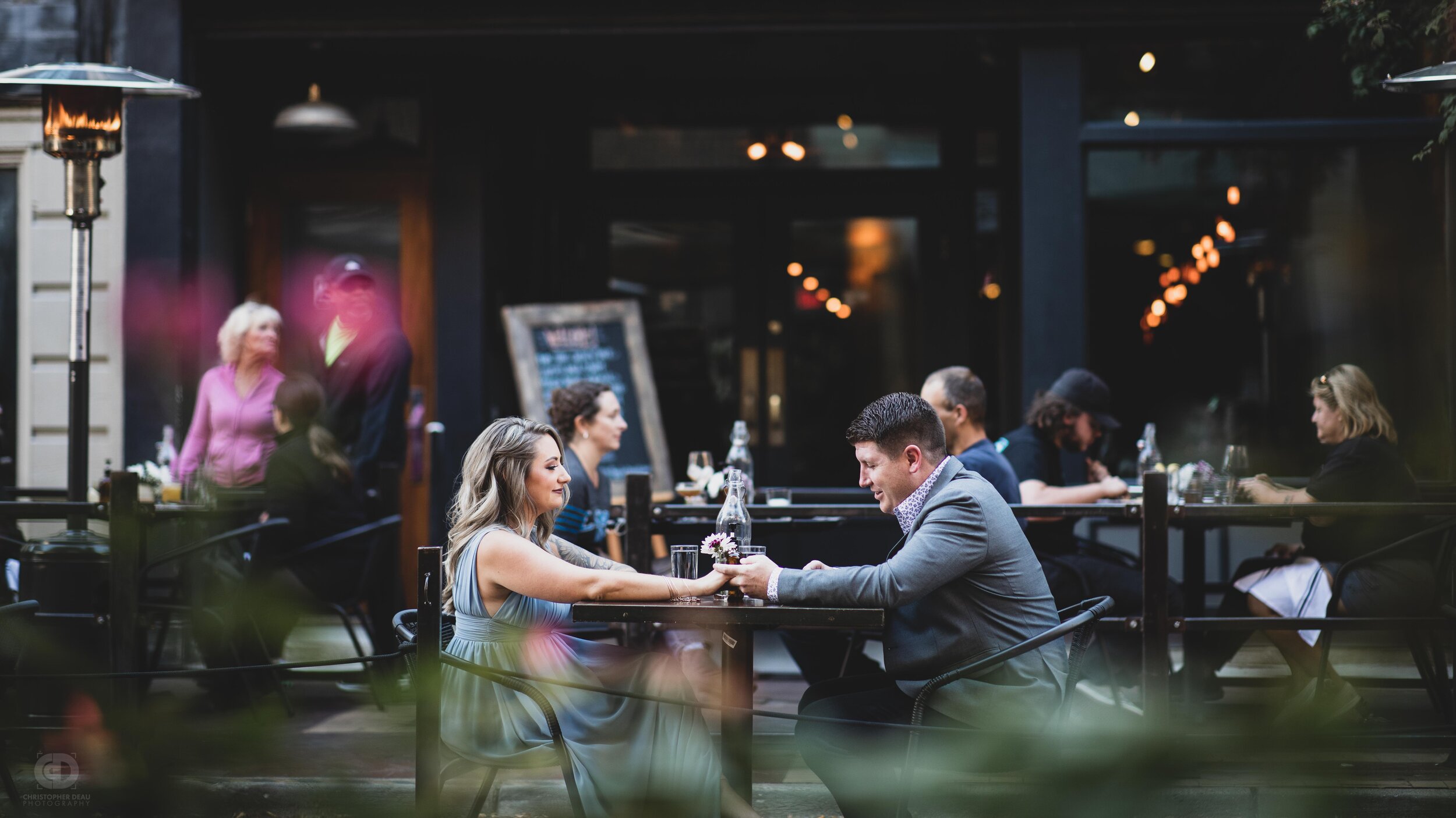 A couple holding hands at outdoor seating downtown Kalamazoo.jpg