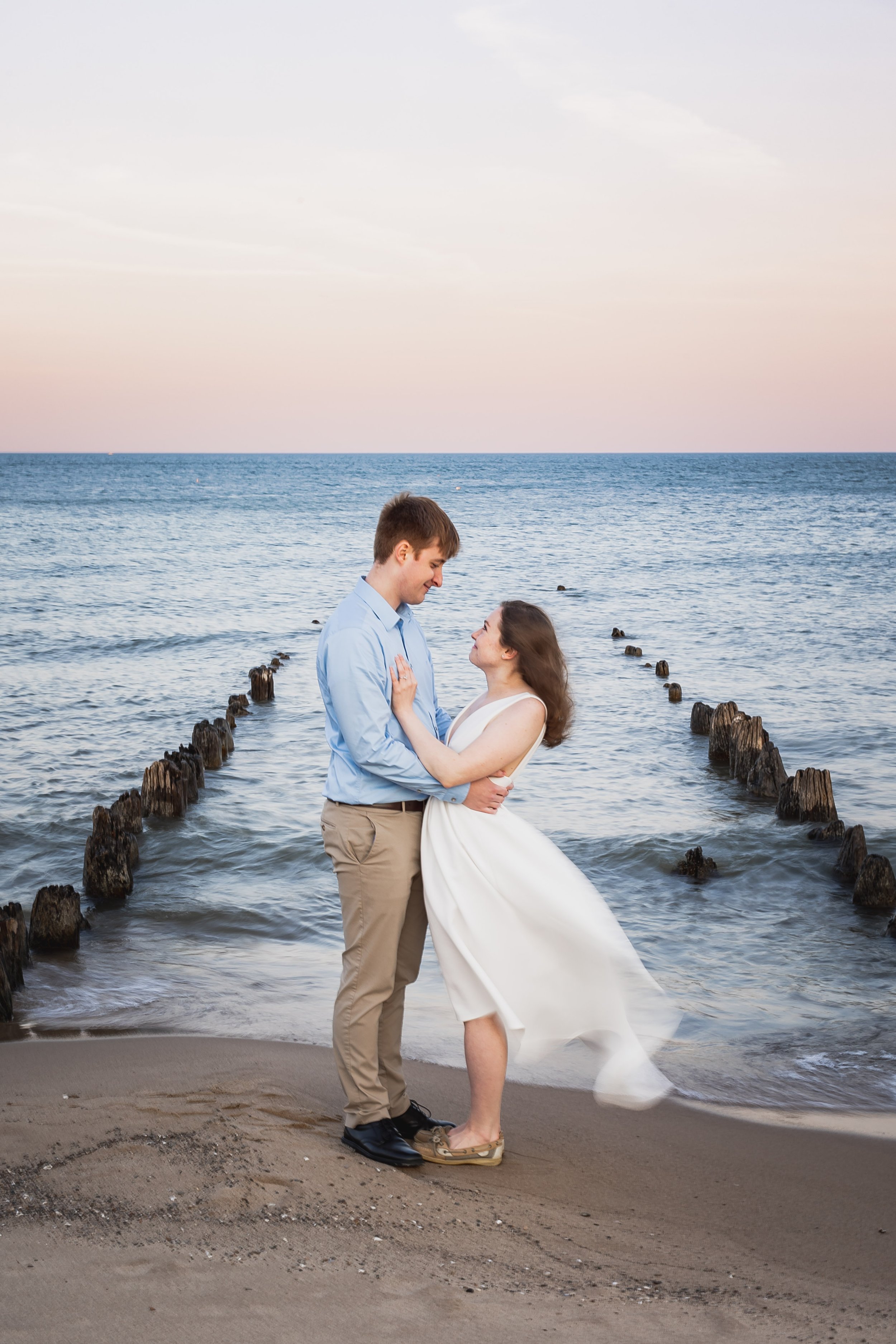  A couple holding each other in front of lake michigan waves 