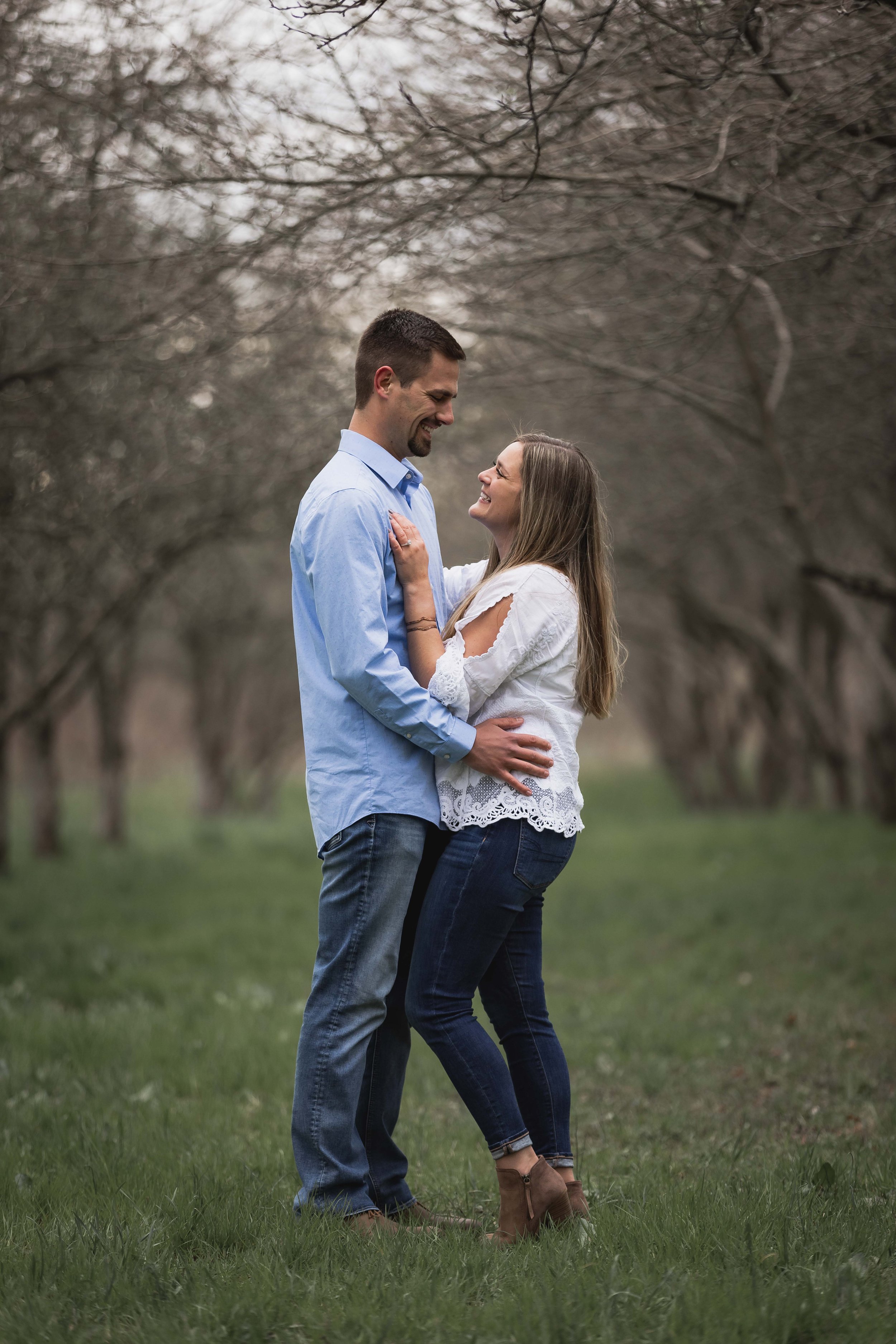  A couple holding each other in an apple orchard 