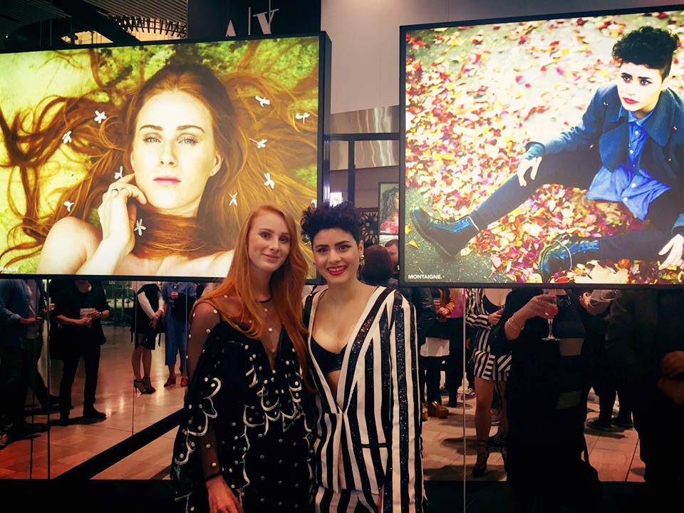 Vera Blue and Montaige stand in front of their portraits. Image via Vera Blue's Facebook page. Top image by Oli Sansom