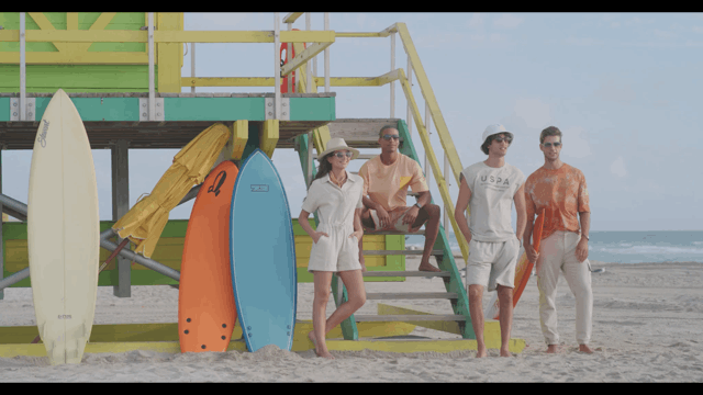 a group hangs out by a lifeguard tower in miami.gif