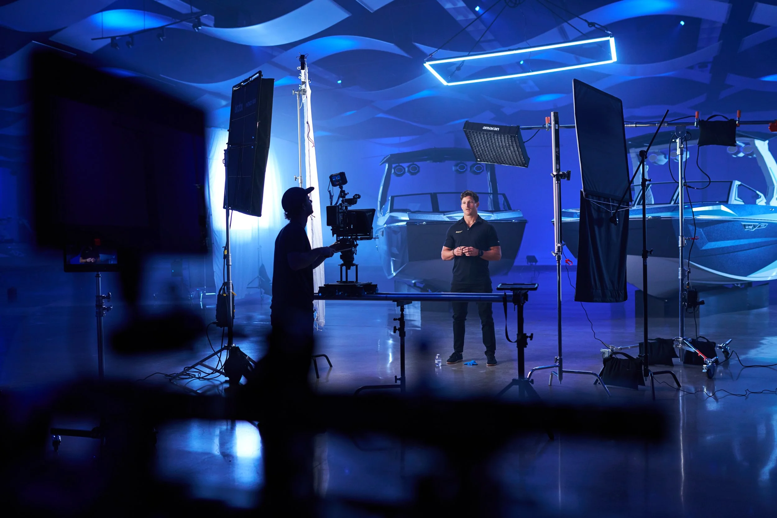joey arcisz operates a camera on a dana dolly in a room with boats and film lights surrounding him