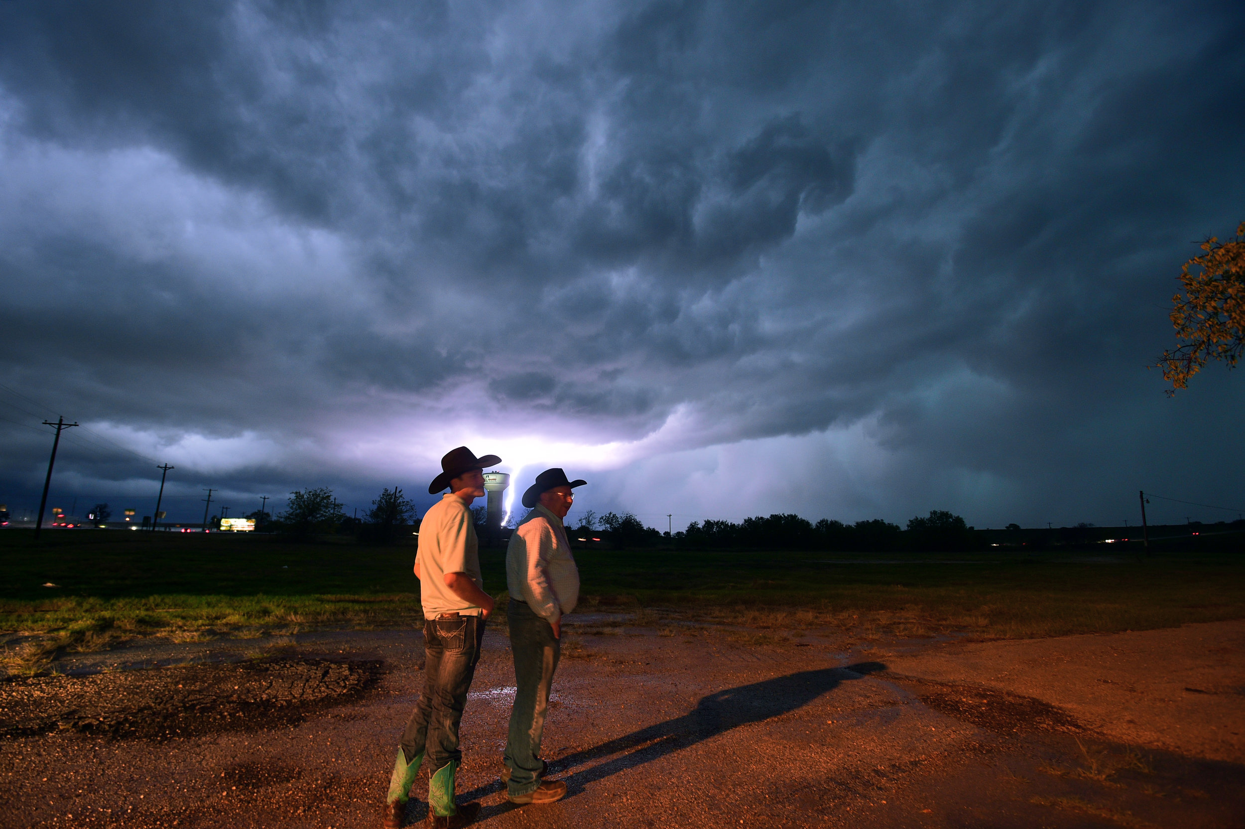 Lightning strikes near the water tower at Loop 288 and I-35 as Chance Foster and Mark Foster watch the fast moving clouds and lightning as a severe storm system moves in across Denton County, Thursday, November 5, 2015, in Denton, TX.