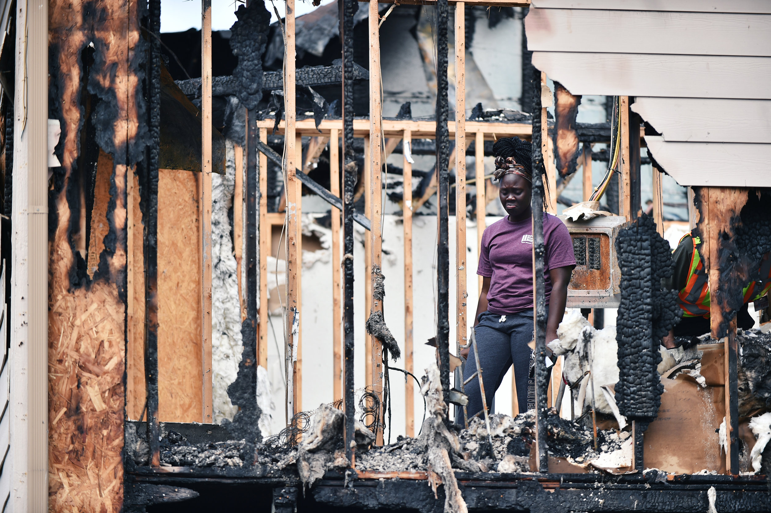 Charot Kenyi, a junior biochemistry major at Texas Woman's University and a U.S. Army reservist, reacts while being escorted through the remains of her burned-out apartment after an overnight fire burned several units at the TWU Select Apartments at