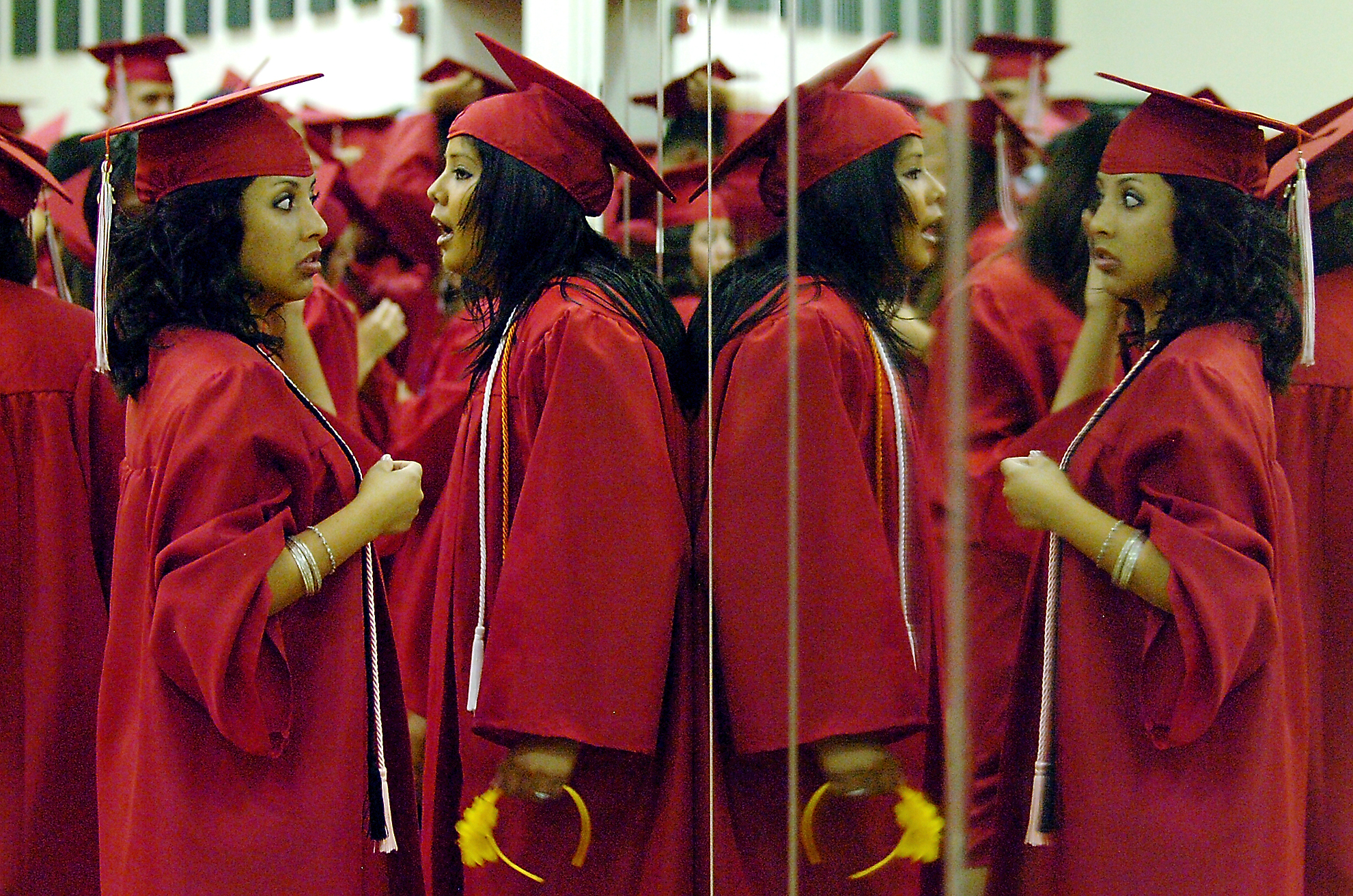 Ryan High School senior Carmen Fuentes checks her hair with a wall of mirrors as Socorro Gutierrez waits, before the start of the Ryan graduation, Friday, June 4, 2010 at The UNT Coliseum in Denton.