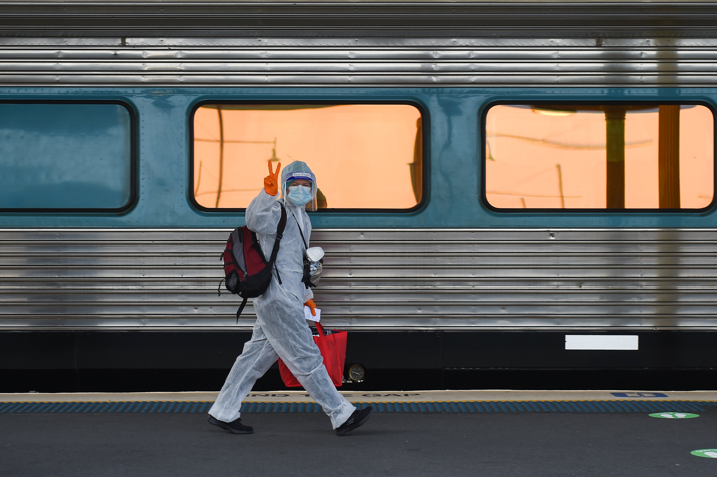  (Photo Mark Jesser) Albury Train Station. 
Border closure due to COVID-19. XPT bound for Sydney. NSW Police check all passengers before the train can depart -- Passenger wearing overalls, face shield and respirator boards the XPT. 