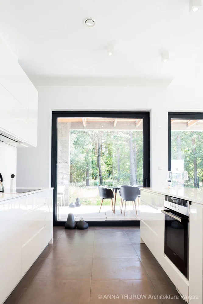 Duże okna z widokiem na las w nowoczesnym domu dla cztero-osobowej rodziny pod Szczecinem | kompleksowy projekt ANNA THUROW Architektura i wnętrza