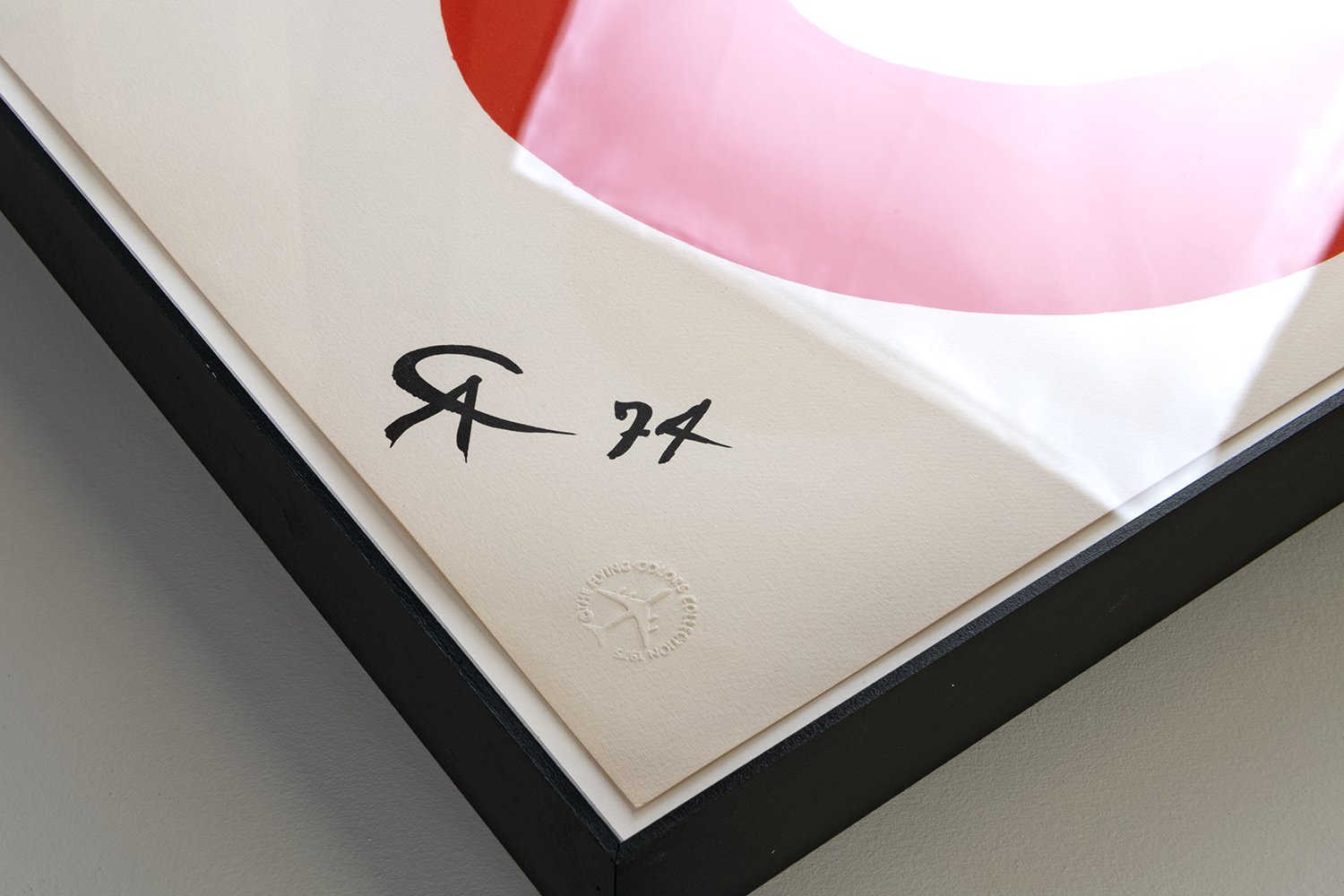 Close-up view of a framed artwork with a signature and limited edition number, indicating it is the 77th print of a series. The signature is in black ink, accompanied by a circular embossed stamp reading 'GICLÉE PRINT COATER EDITIONS'.