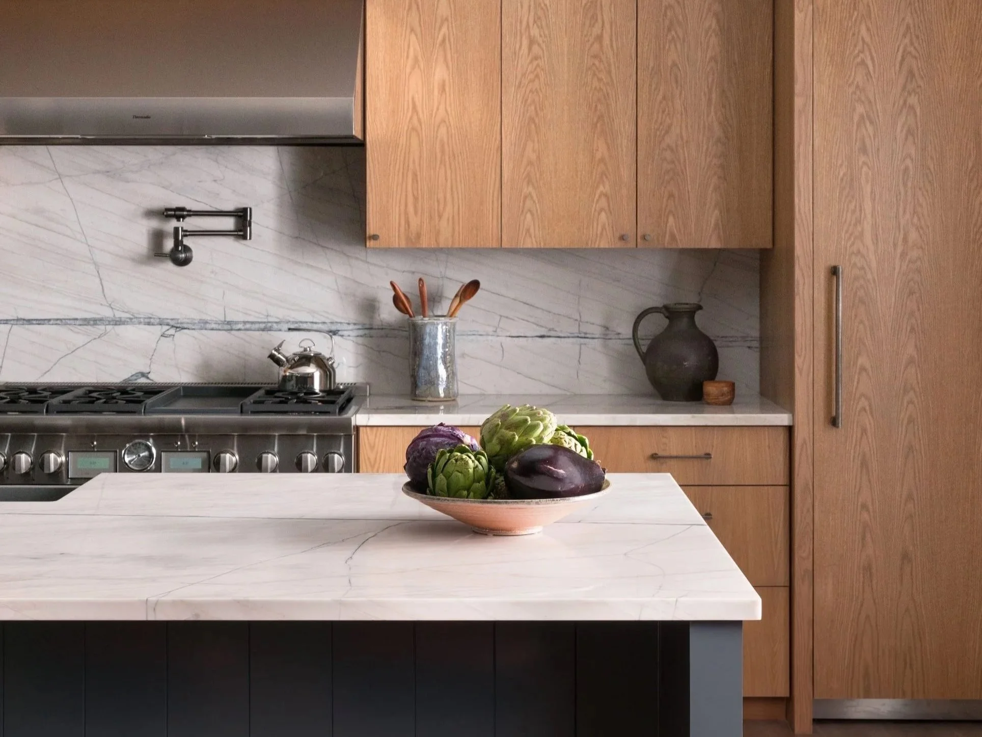 Kitchen island, countertops and full-height backsplash featuring Lux Supreme quartzite of tan base with grey-blue lines.