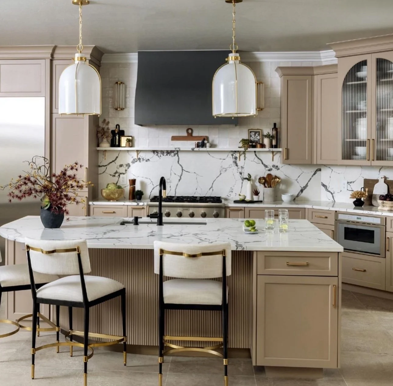 Compact warm tan kitchen features marble-style Invisible Grey quartz island, countertops, and full-height backsplash.