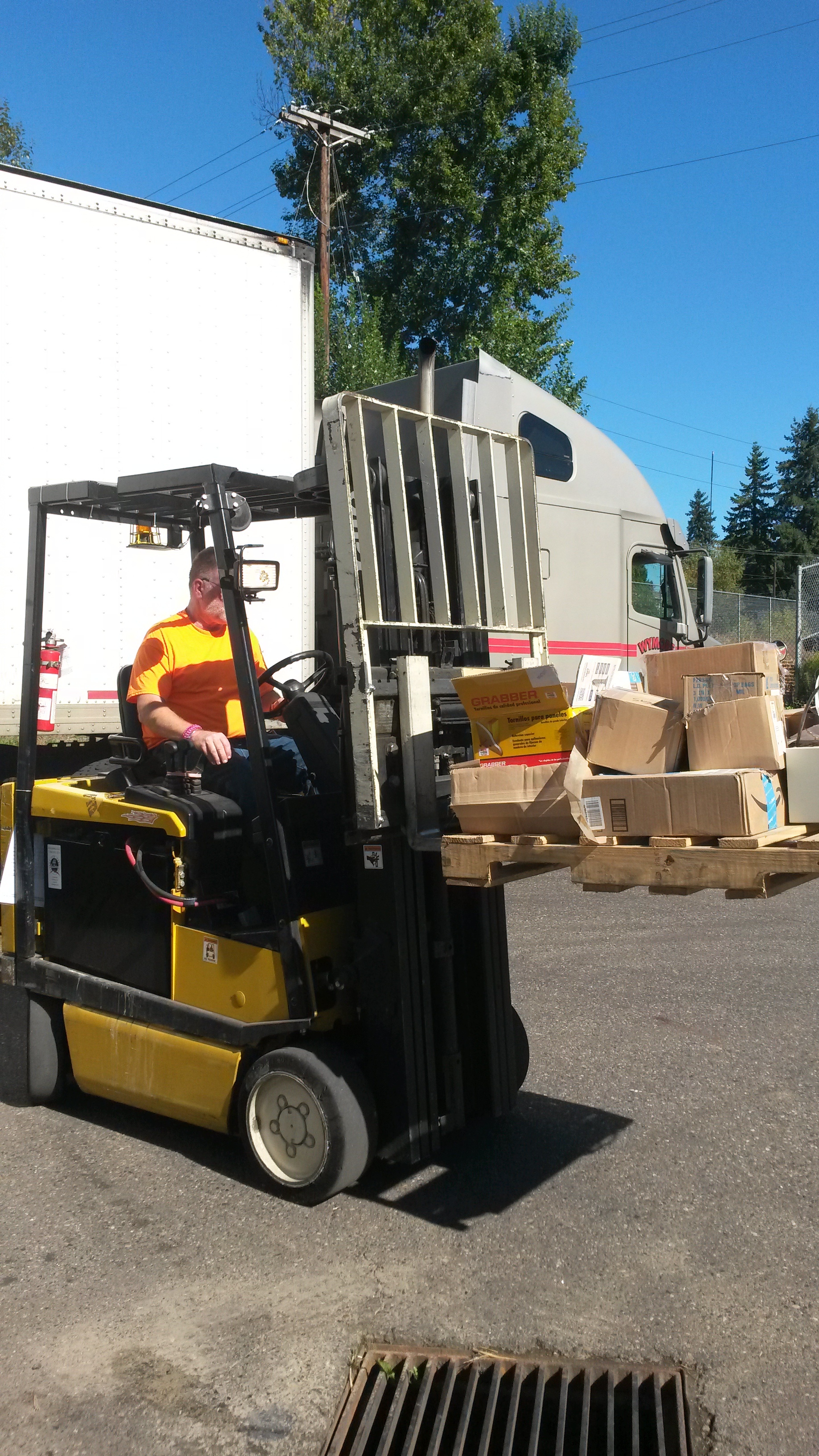 A forklift driver at Exceed moving many random items into the warehouse.
