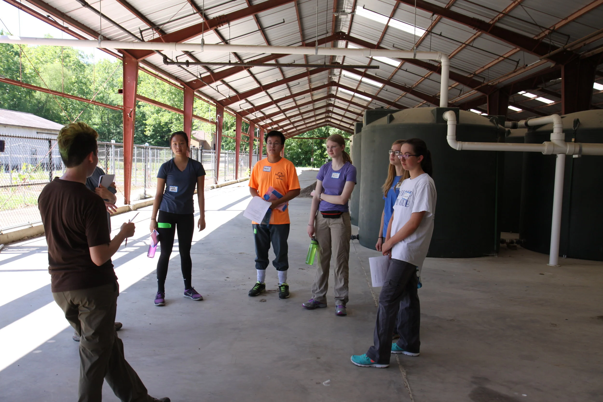Tyson undergraduate fellow Aspen Workman (left) explains how rain water captured from the roof is used to water prairie plant experiments in the Tyson research garden. Aspen was a participant in the SIFT and TERF programs during high school and now plans for a career in ecological research.