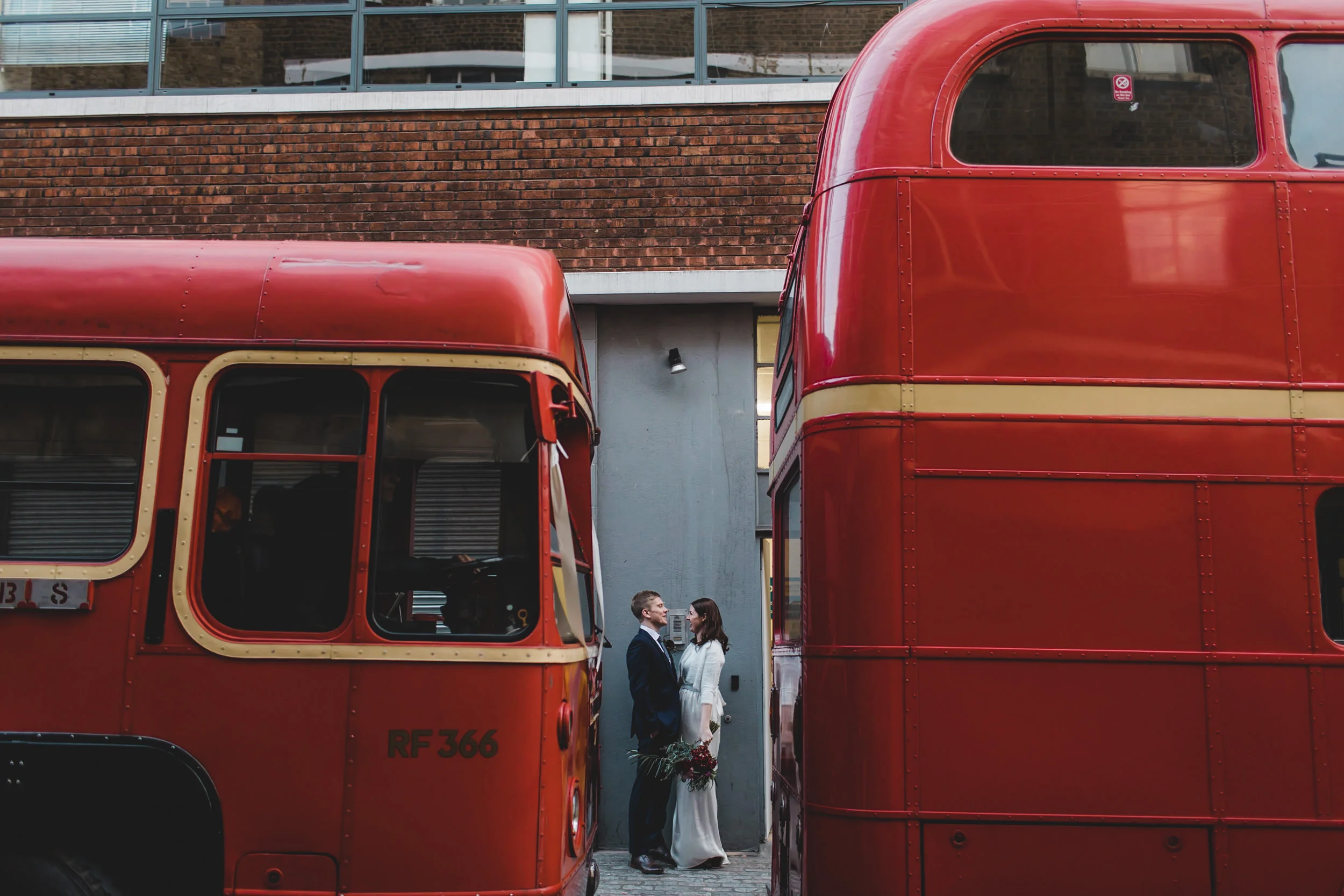 just married couple between two london buses