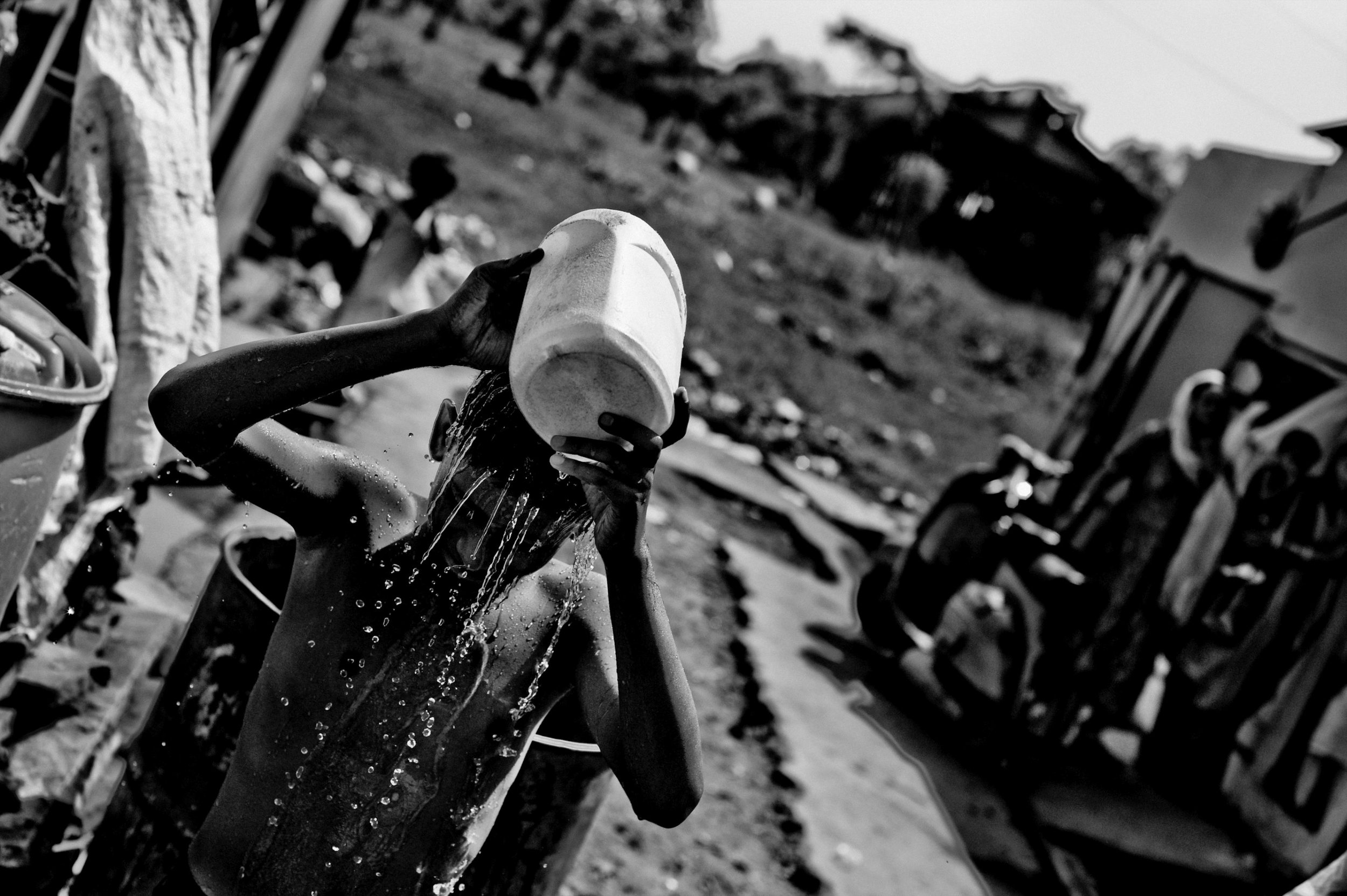  A boy bathes in front of the shack he lives on the site of the Union Carbide plant behind him in the city of Bhopal in the state Madhya Pradesh, India. 