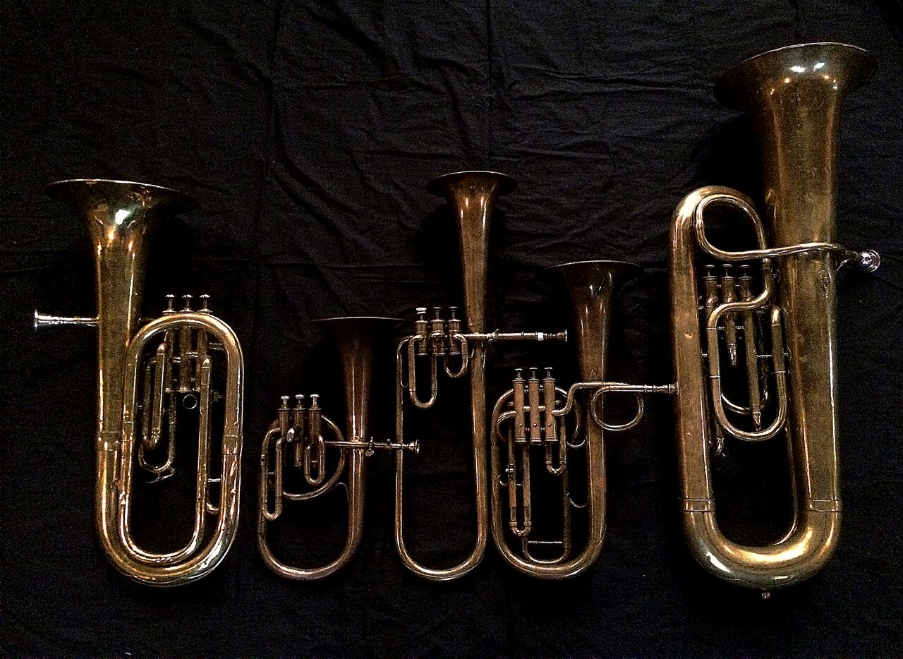 Left to Right: Baritone saxhorn in B-flat by Couesnon (44139, 94 Rue D’angouleme Exposition Universelle De Paris, 1900) , Contralto saxhorn in B-flat by J. Grass (32 Rue des Ponts de Comines, Lille, est. 1868, Contralto saxhorn in B-flat by Adolphe Sax (Paris, c. 1849-1850), sold by Distin & Sons, Cranbourne St. Leicester Square, London, Tenor saxhorn in F/E flat/D by Antoine Courtois (Paris, c. 1855), sold by Arthur Chappell (London), Contrabass saxhorn in E-flat by E. Daniel (7167, Marseille, c. 1850).