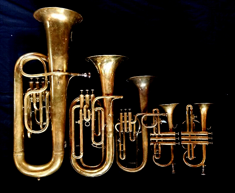 Left to Right: Contrabass saxhorn in E-flat by E. Daniel (7167, Marseille, c. 1850). Baritone saxhorn in B-flat by Couesnon (44139, 94 Rue D’angouleme Exposition Universelle De Paris, 1900), Tenor saxhorn in F/E flat/D by Antoine Courtois (Paris, c. 1855), sold by Arthur Chappell (London), Cornet in B-flat/A by Couesnon (no makers address or serial number, Paris), Cornet in B-flat/A F. Besson (44292, 96 Rue D’angouleme, Paris c. 1892).