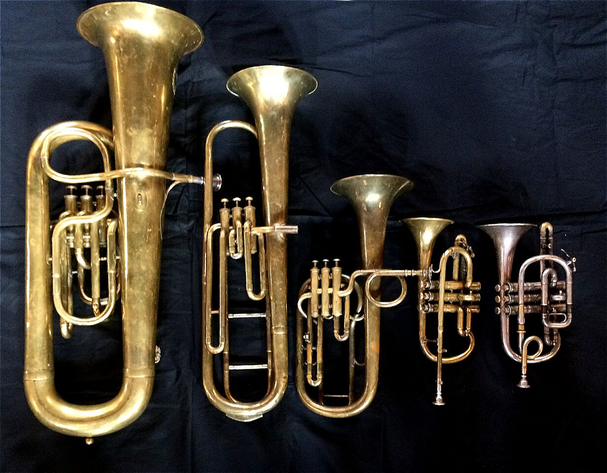 Left to Right: Contrabass saxhorn in E-flat by E. Daniel (7167, Marseille, c. 1850), Baritone saxhorn in C/B flat by Couturier (Lyon, c. 1865), Tenor saxhorn in F/E flat/D by Antoine Courtois (Paris, c. 1855), sold by Arthur Chappell (London) , Cornet in E-flat by Couesnon (94 Rue D’angouleme Exposition Universelle De Paris 1900), Cornet in C/B-flat by Henry Distin New American Model (9580, Williamsport, PA, c. 1895).