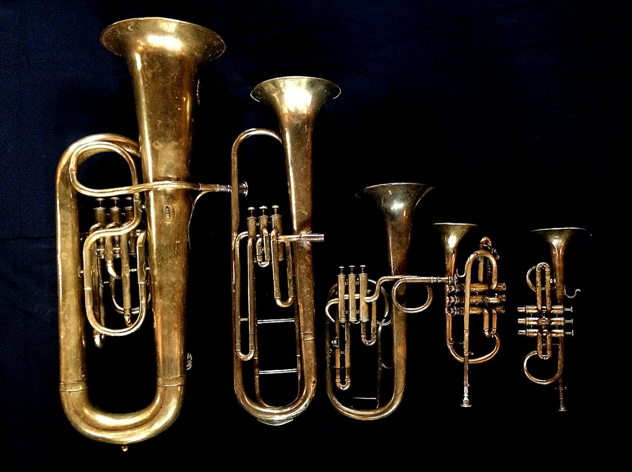 Left to Right: Contrabass saxhorn in E-flat by E. Daniel (7167, Marseille, c. 1850), Baritone saxhorn in C/B flat by Couturier (Lyon, c. 1865), Tenor saxhorn in F/E flat/D by Antoine Courtois (Paris, c. 1855), sold by Arthur Chappell (London) , Cornet in E-flat by Couesnon (94 Rue D’angouleme Exposition Universelle De Paris 1900), Cornet in E-flat by Henry Distin (Gt. Newport Street, London, c. 1851-1868),.