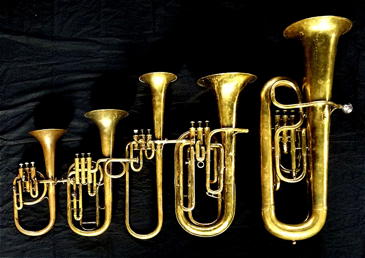 Left to Right: Contralto saxhorn in B-flat by J. Grass (32 Rue des Ponts de Comines, Lille, est. 1868, Tenor saxhorn in F/E flat/D by Antoine Courtois (Paris, c. 1855), sold by Arthur Chappell (London), Contralto saxhorn in B-flat by Adolphe Sax (Paris, c. 1849-1850), sold by Distin & Sons, Cranbourne St. Leicester Square, London, Baritone saxhorn in B-flat by Couesnon (44139, 94 Rue D’angouleme Exposition Universelle De Paris, 1900) , Contrabass saxhorn in E-flat by E. Daniel (7167, Marseille, c. 1850).