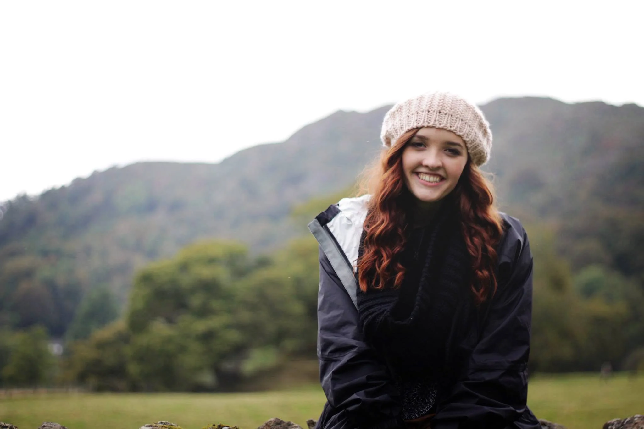 girl in lake district in hat smiling for camera look for the light photo video celine reese