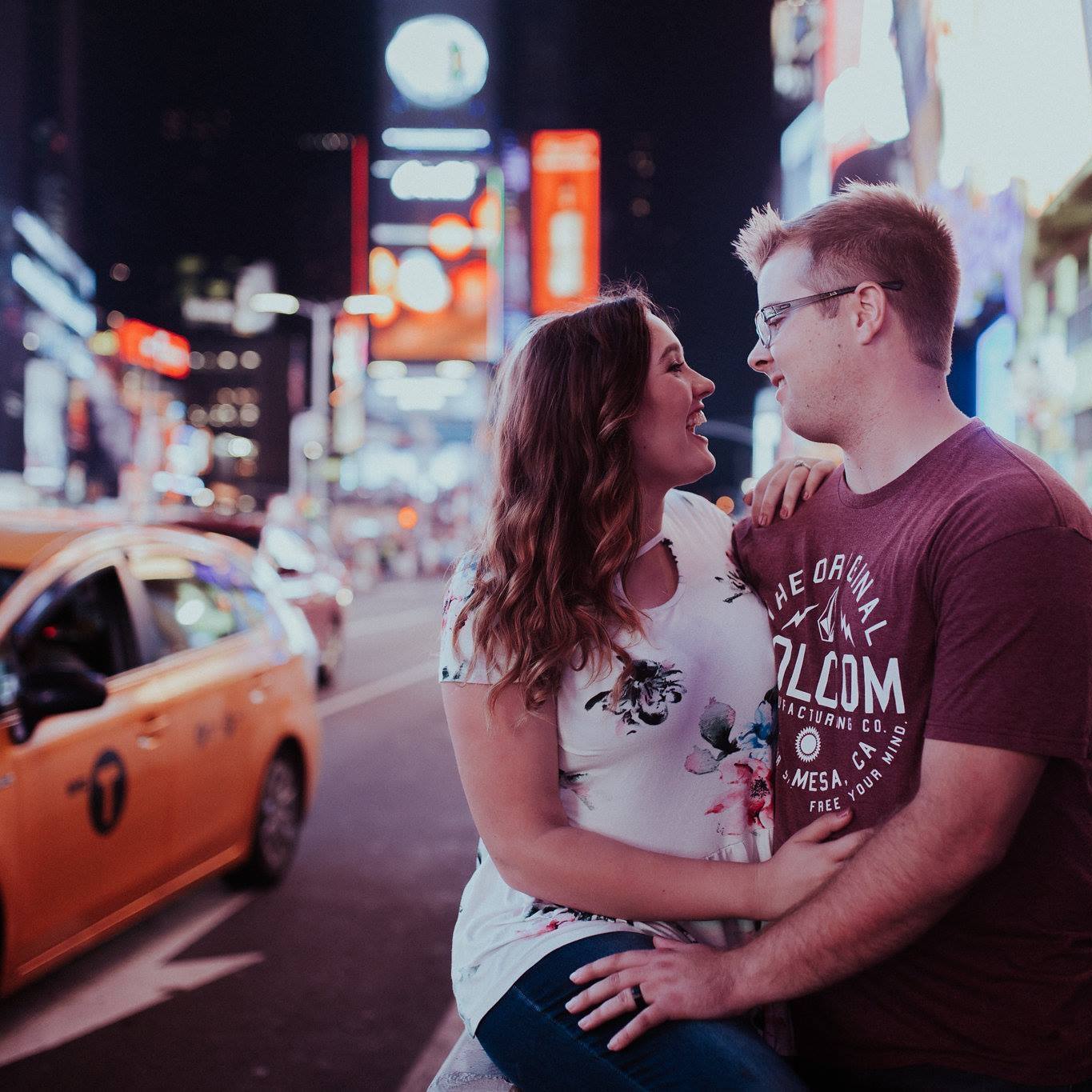 couple embracing new york times square with taxi in the background romantic look for the light photo video celine reese