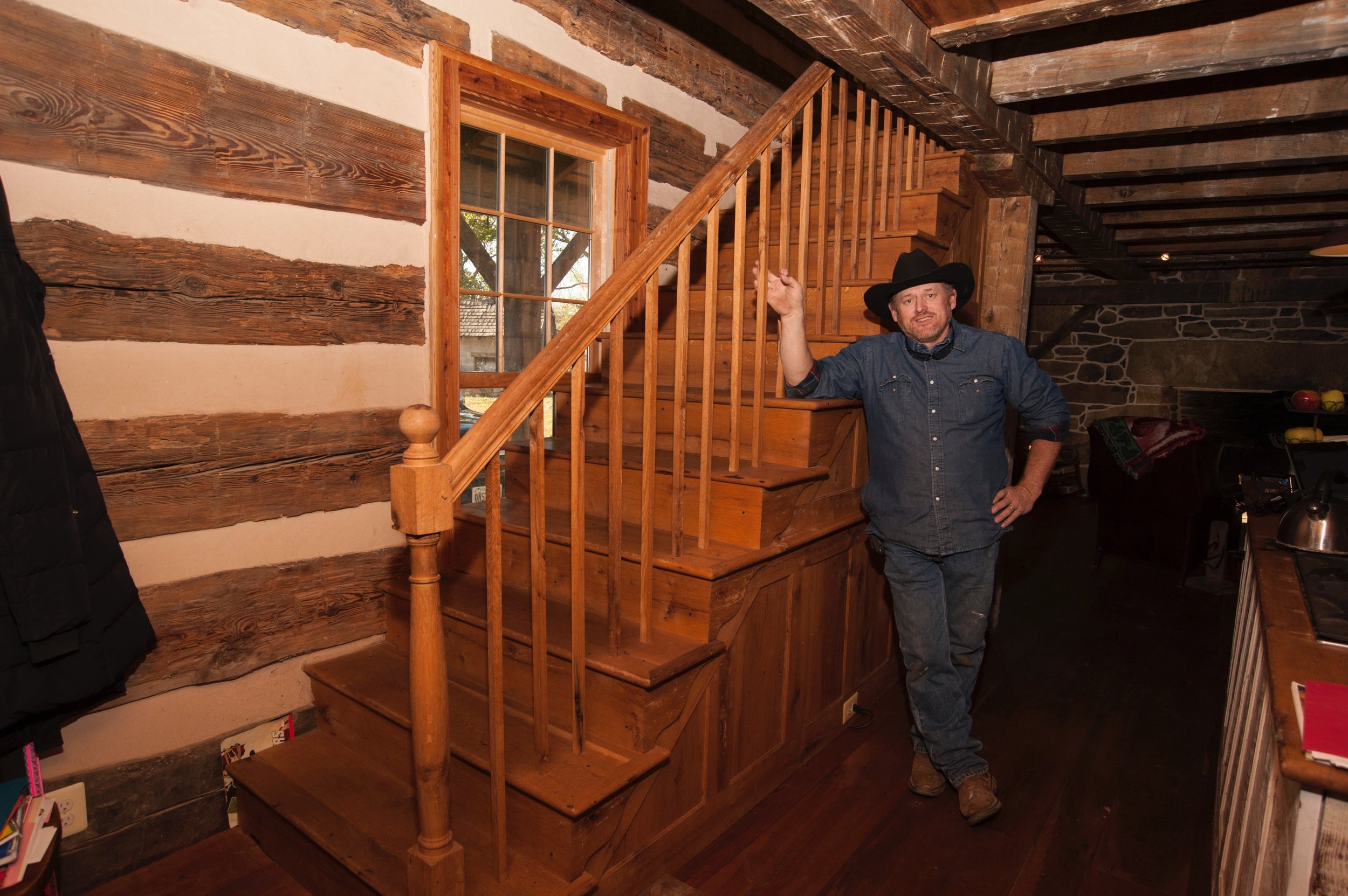  Allen Cochran stands next to the original newel post of the log building. 