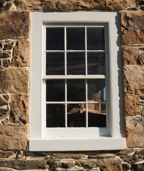  Close-up of window featuring new Marvin window set into custom frame of old wood. 