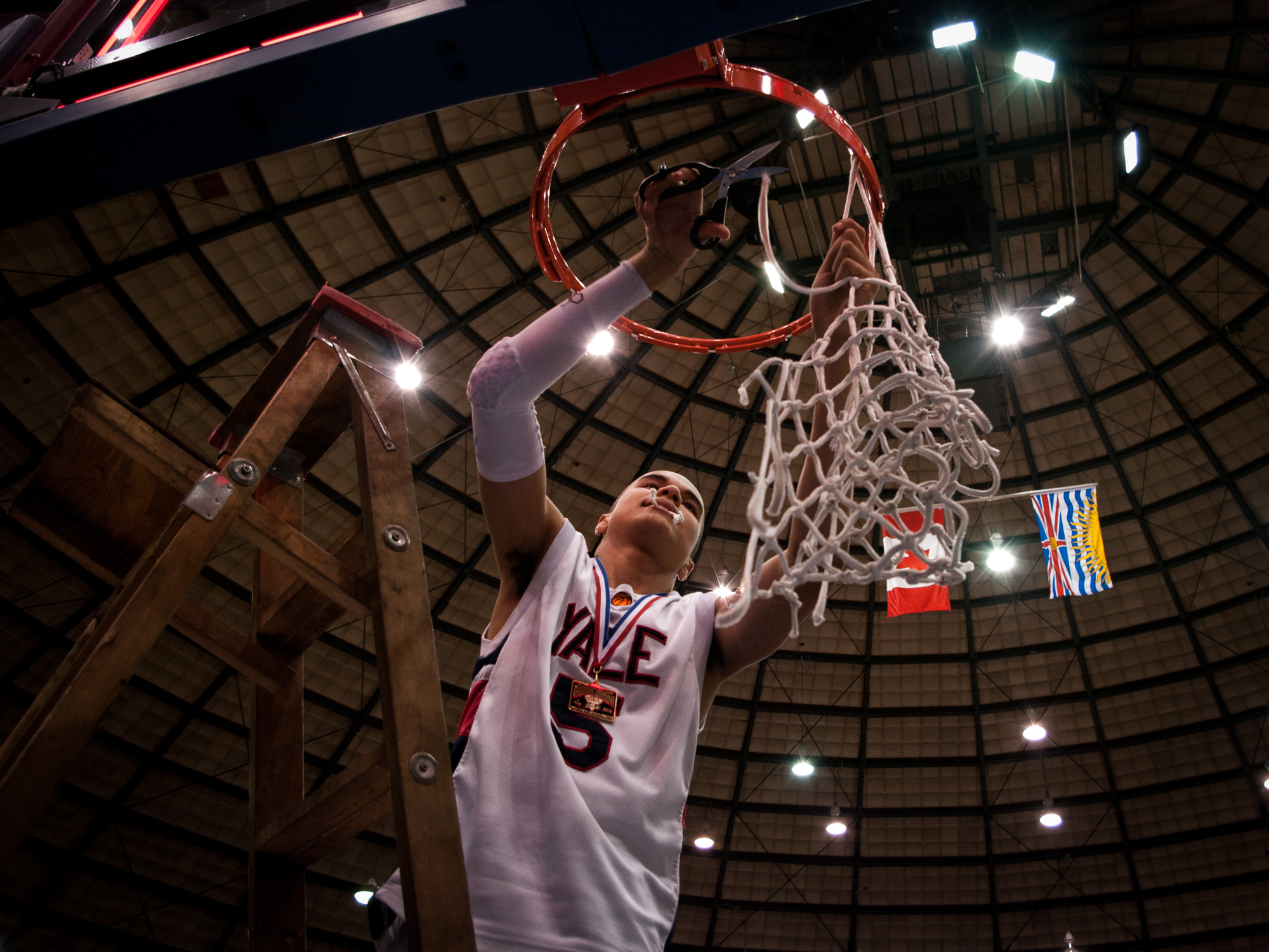 Jordan Blackman cuts down the net after his team won the 2010 BC High School Basketball Championships.
