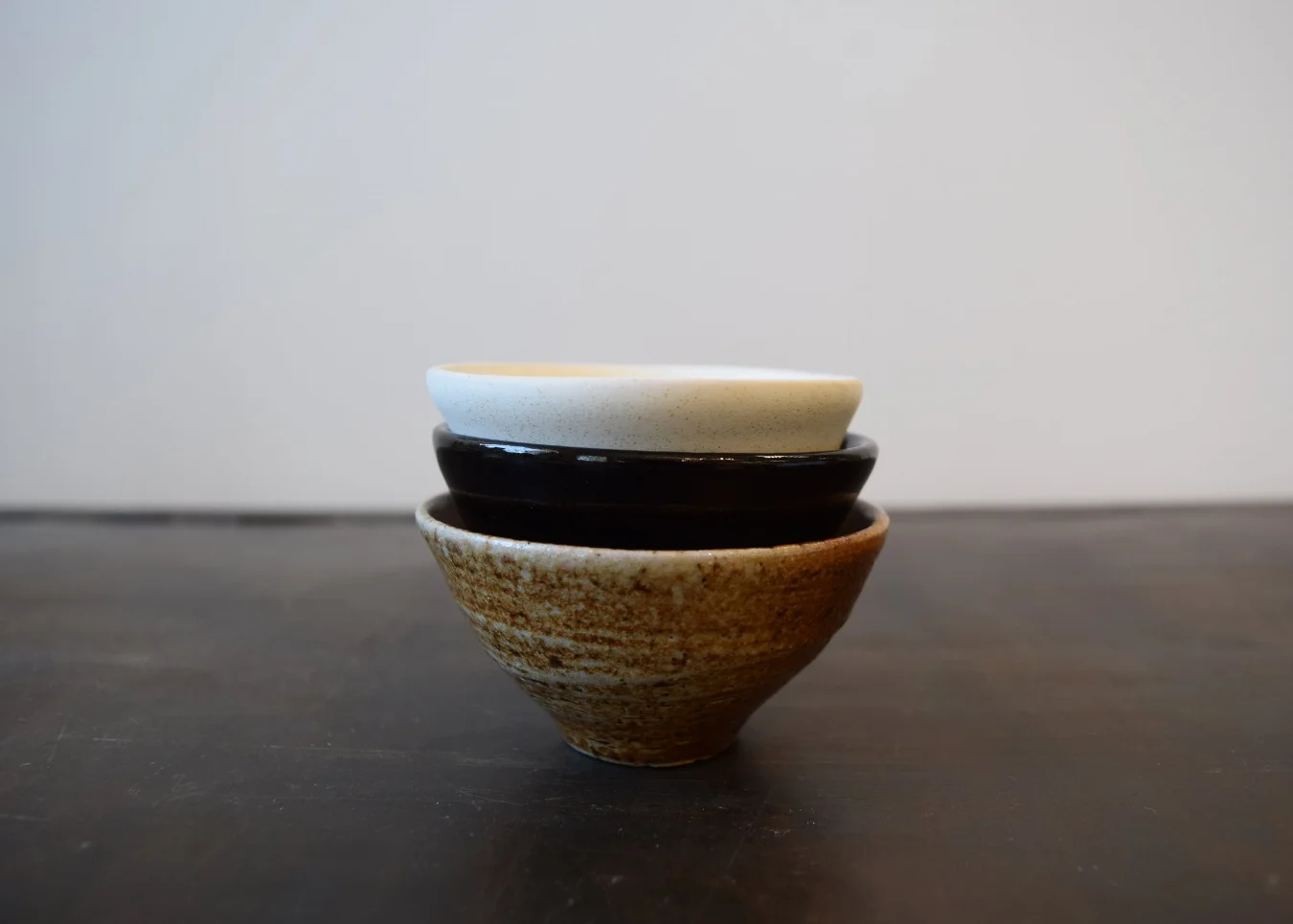 Each set contains a woodfired bowl, showing off the raw clay, as well as a white and black glazed bowl. 