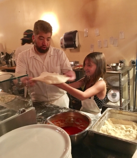 Daughter of a Recipient learning to make pizza with Pizza Taglio owner Tony Giamarita.
