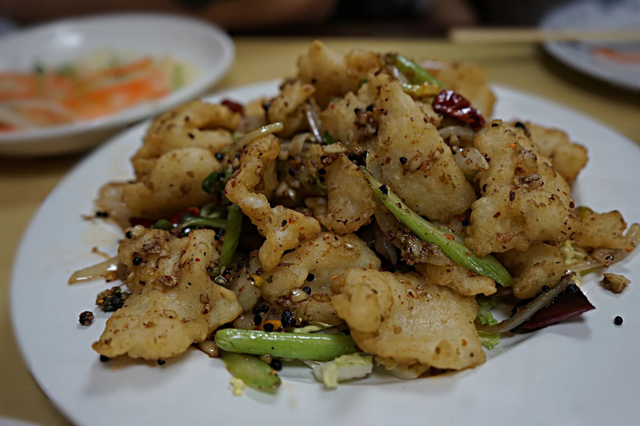 Szechuan Spicy Fish Filet. Green onions, szechuan peppers all fried up together. Its spicy, but it burns so good! Be a thug and put one of the pepper seeds in your mouth, and crunch on it.