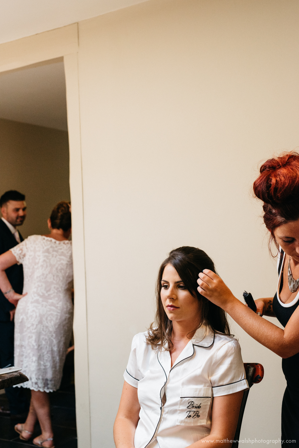 A relaxed photograph of the bride having her hair done