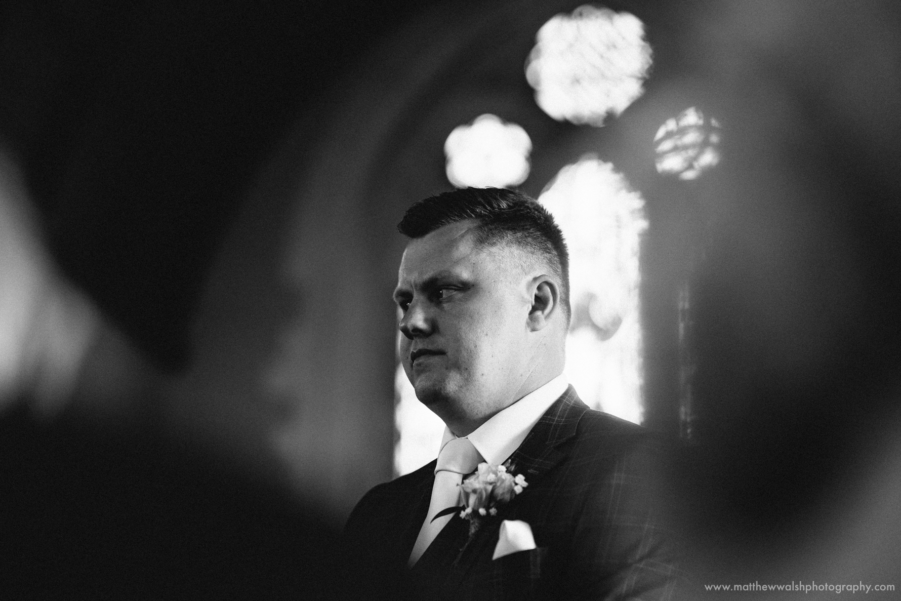 The groom at the church awaiting his bride, looking a little nervous