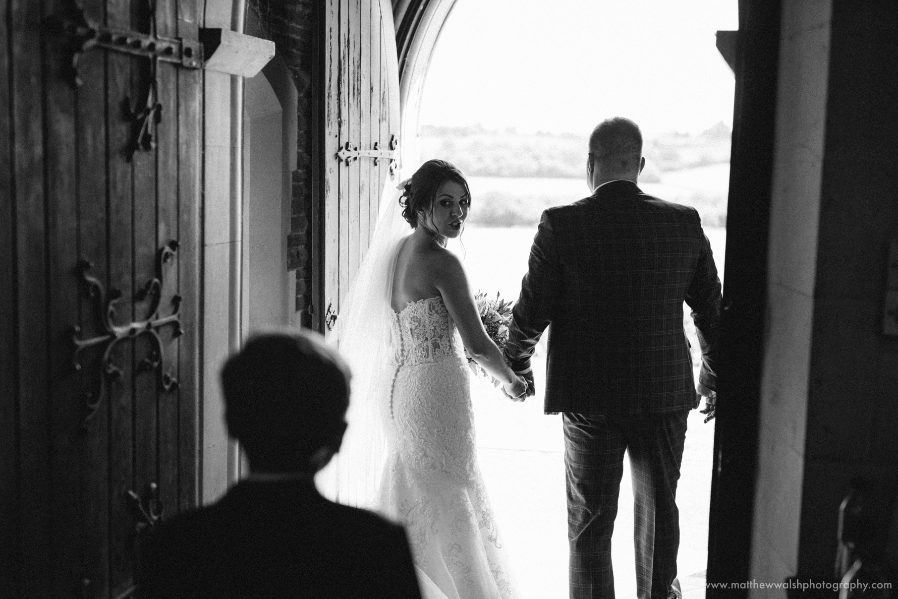 Bride and groom leaving there church into the sunlight