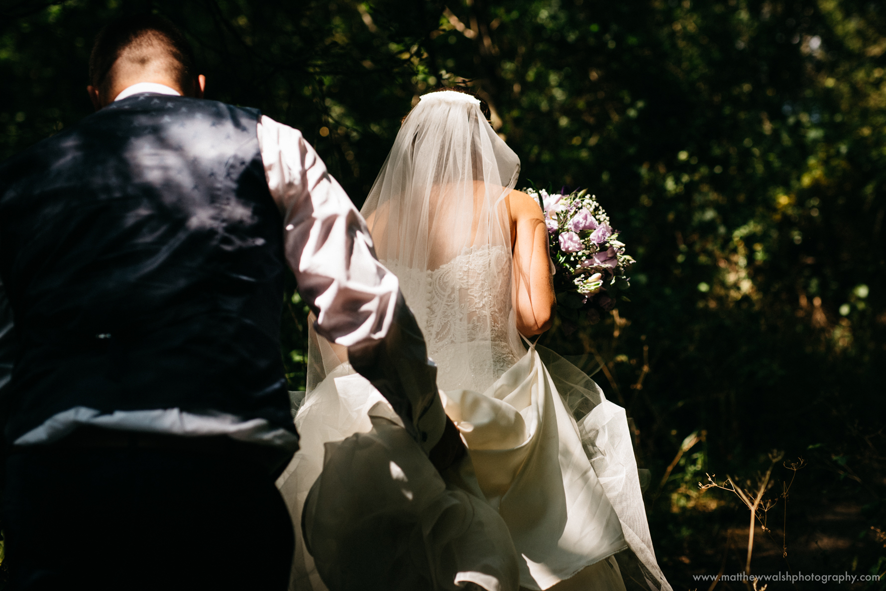 Beautiful natural dappled light falling on the back of there brides dress