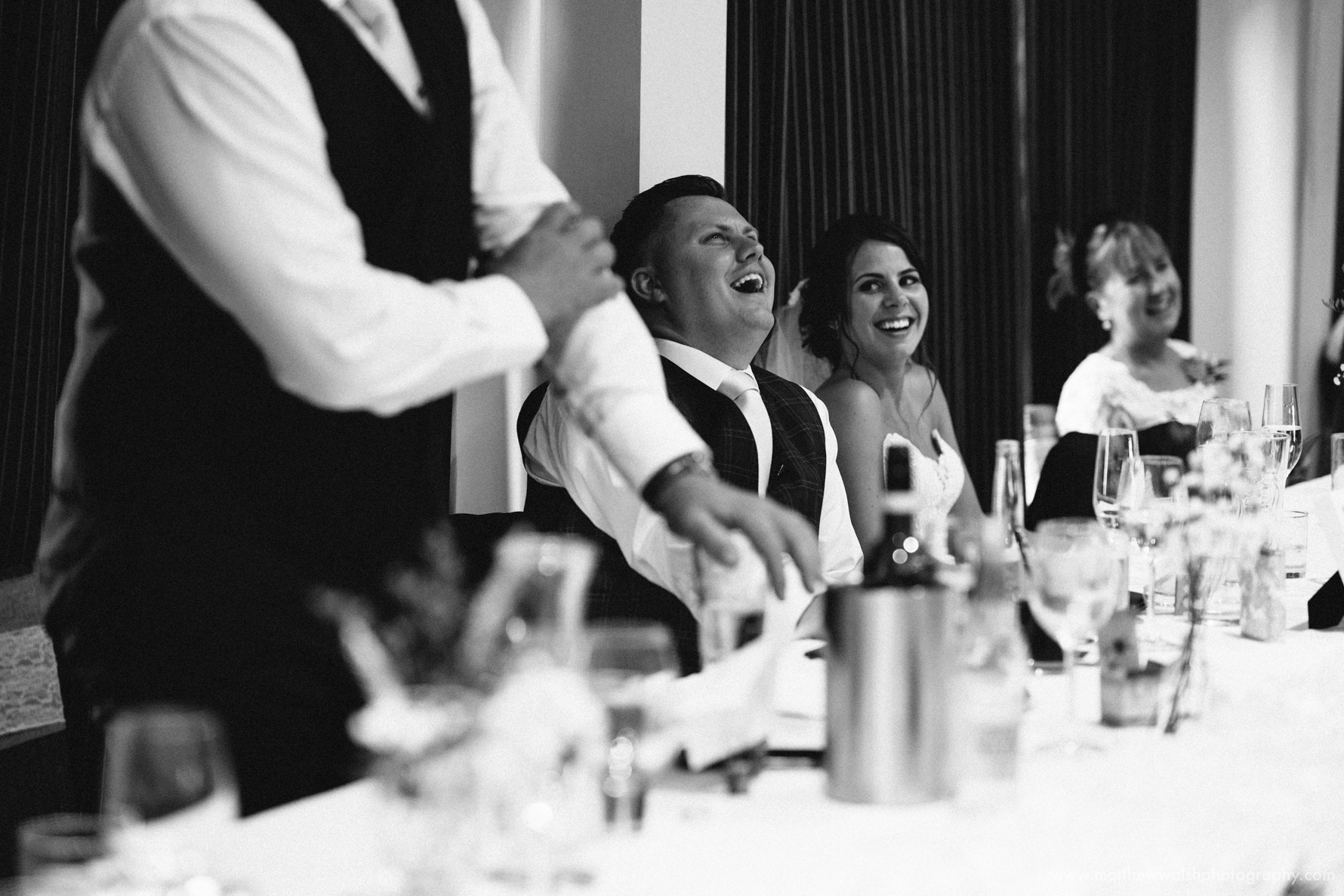 The groom laughing at the best man speech