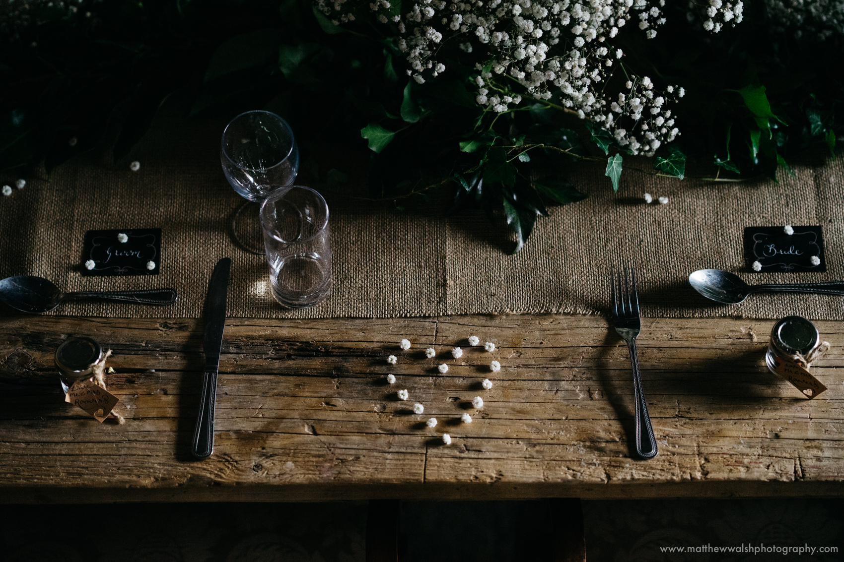 A love heart sits between the bride and grooms table settings