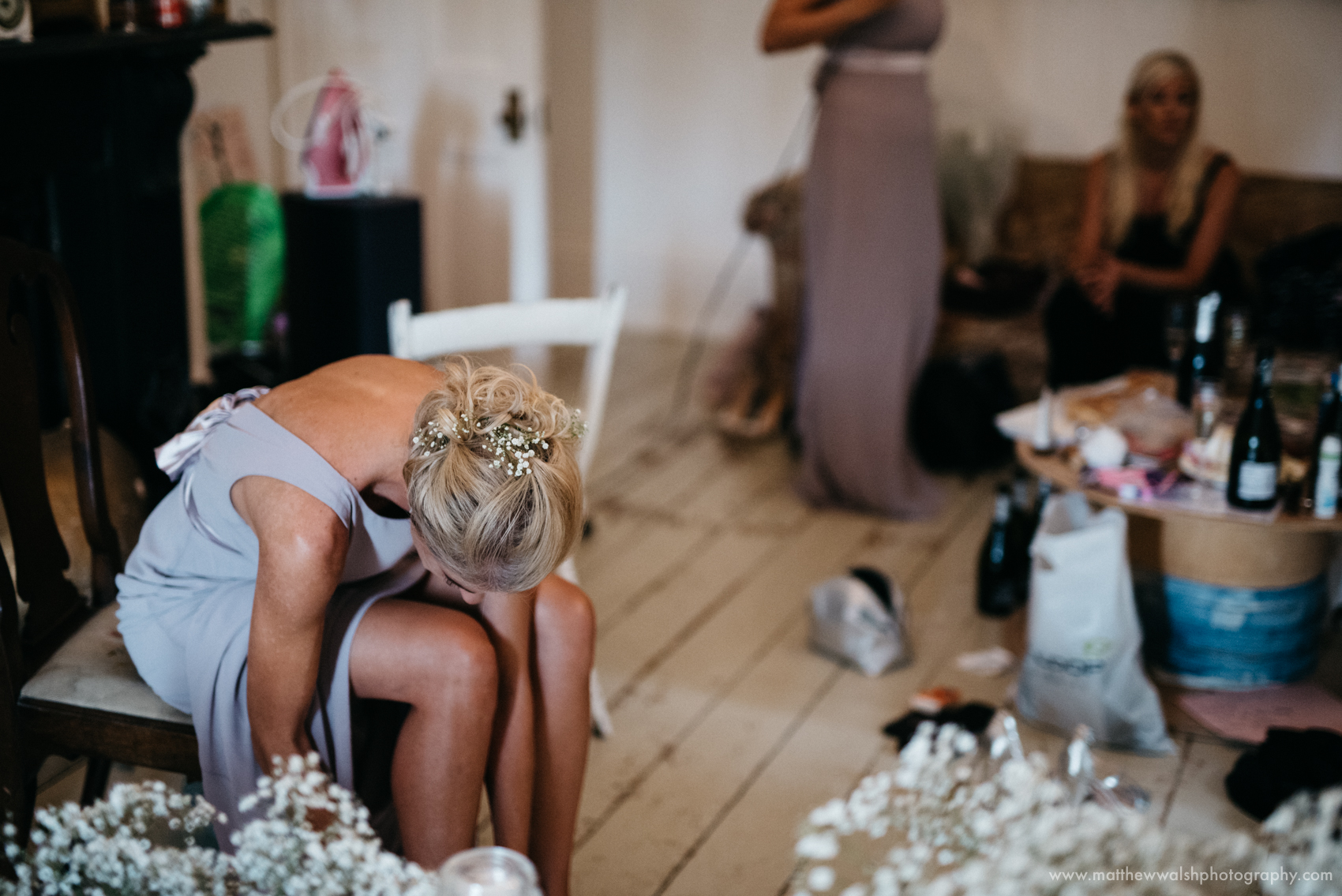 One of the bridesmaids putting her shoes on