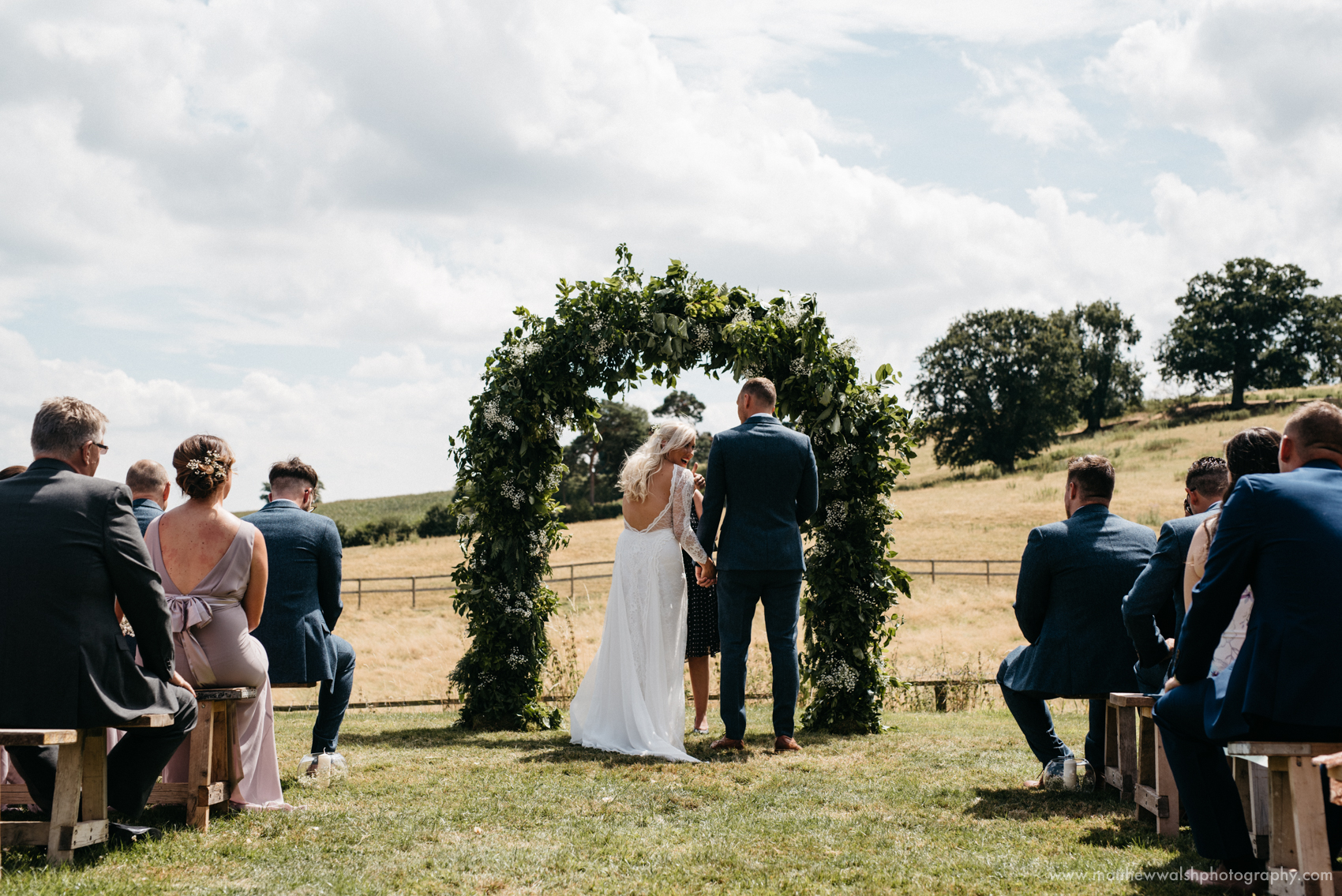 Making their vows under a floral arch that they have made themselves