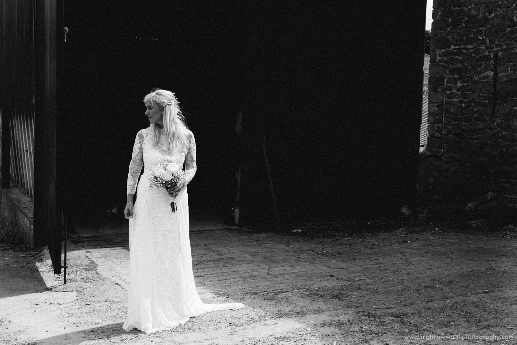 The bride looking elegant and sophisticated in her lace wedding dress, captured in black and white to make the dress really stand out