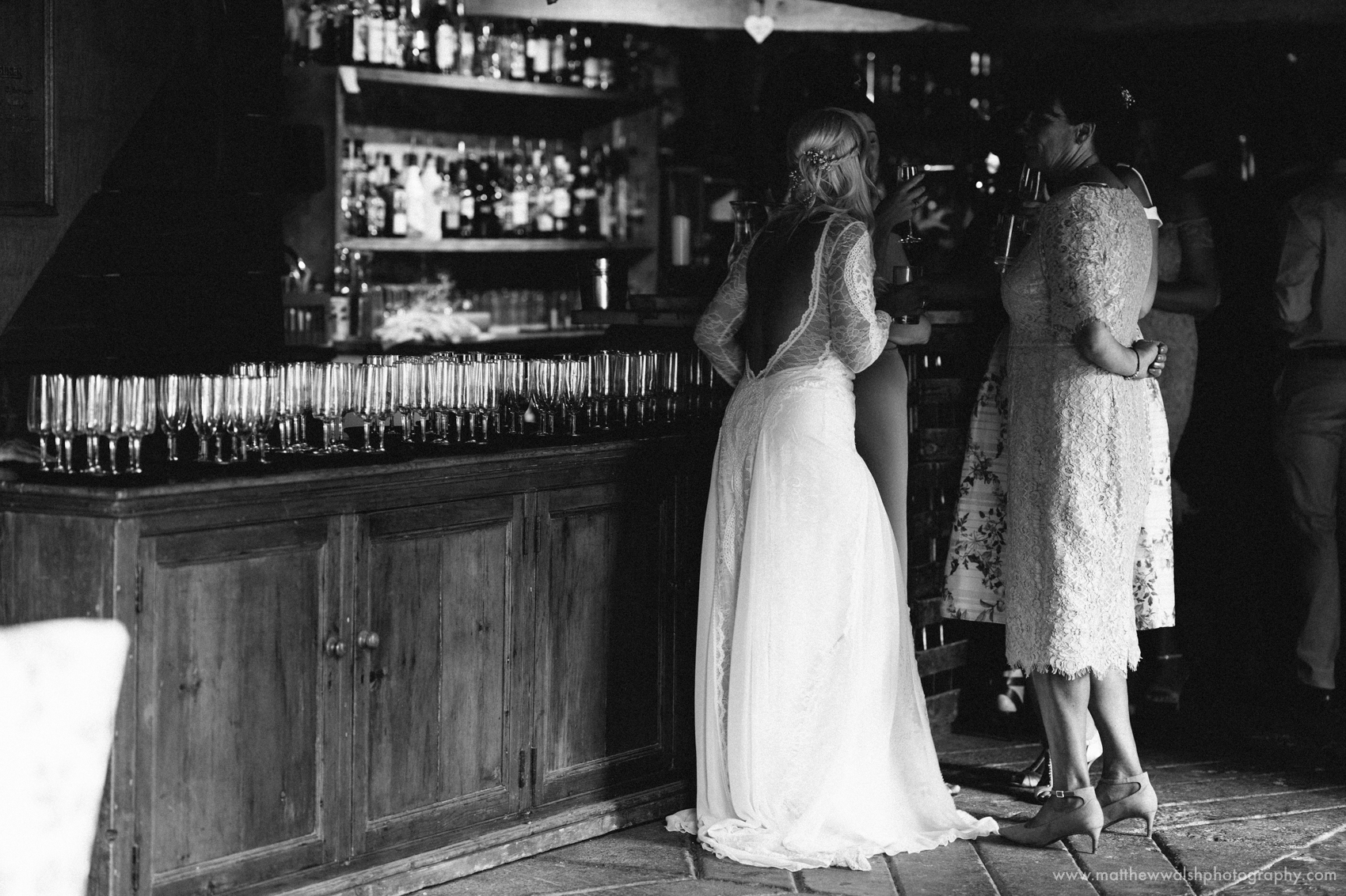 The bride standing next to the glasses ready for the Prosecco to be poured