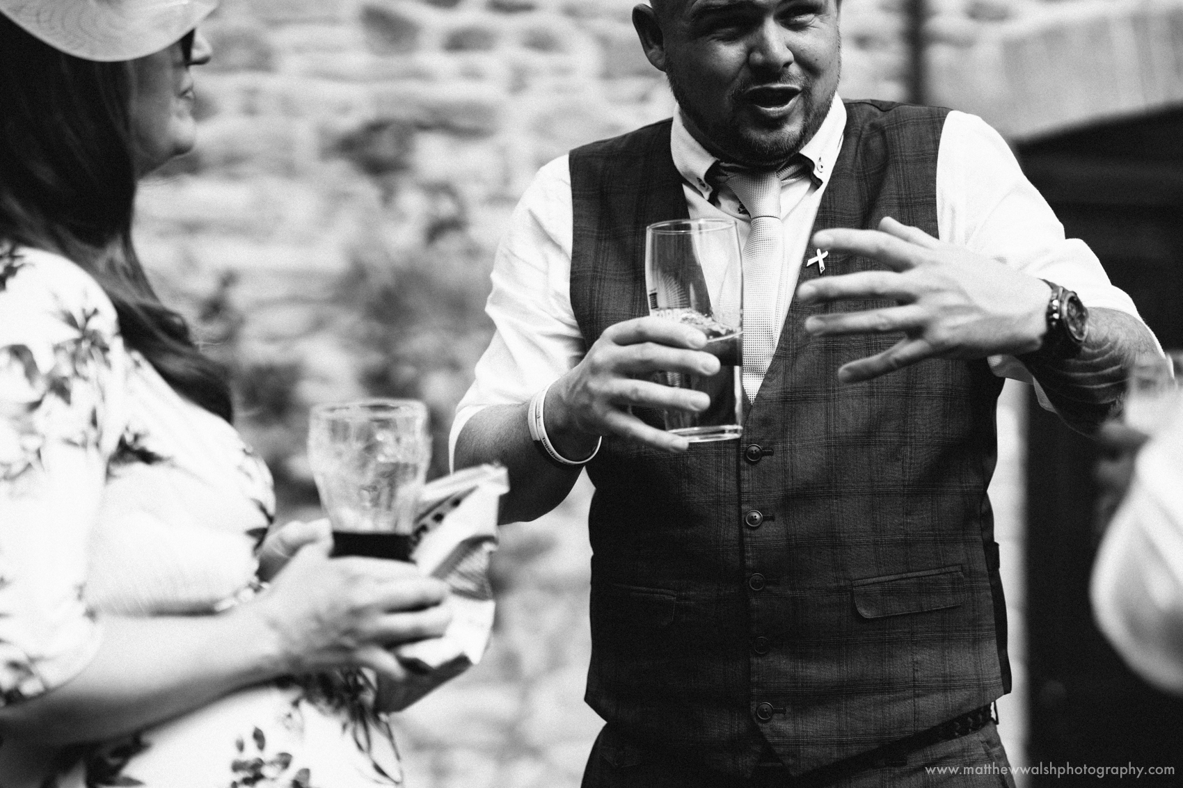 A guest getting quite animated as he tells a story to another wedding guest