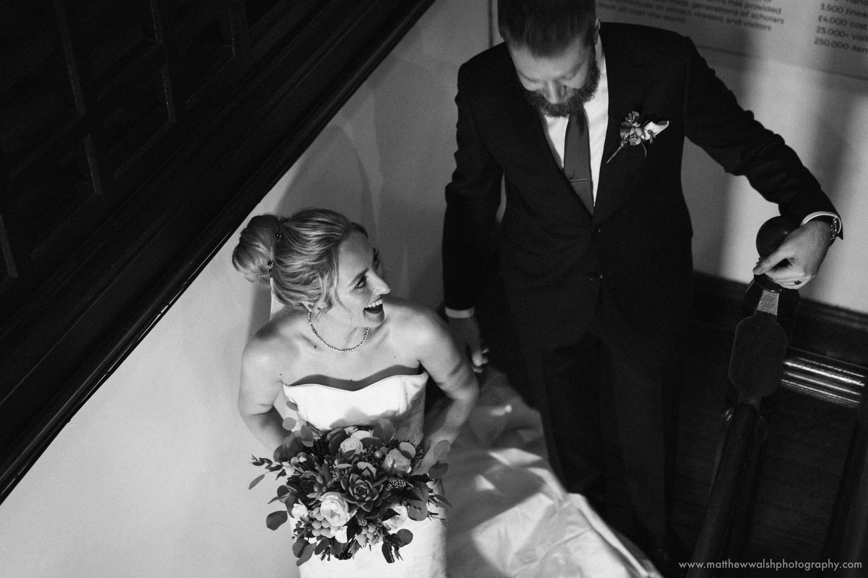 An unposed moment has the happy couple head down the stairs back to the main wedding party
