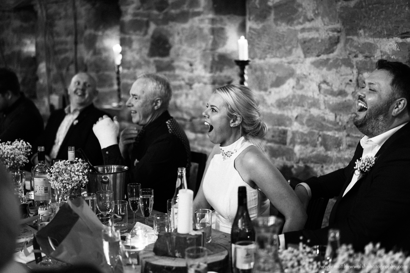 The bride and groom laughing at the poem