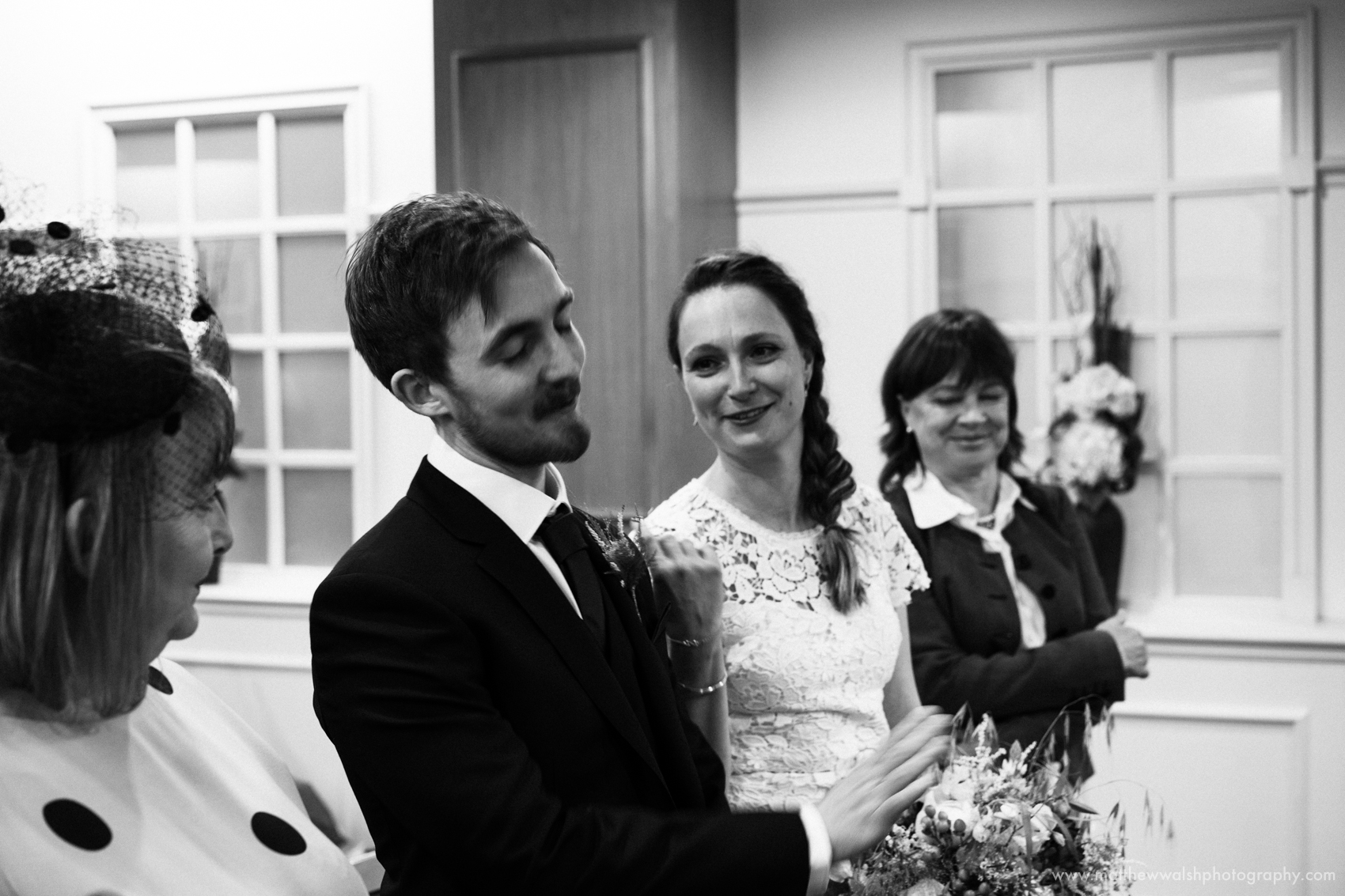 A black and white photograph of the bride and groom sharing their wedding vows