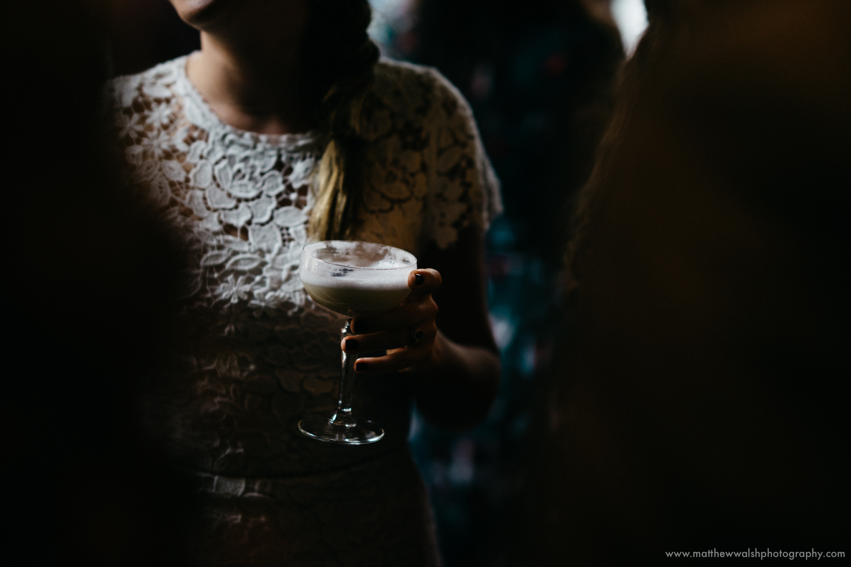 A slither of light catches the brides drink and dress, not a moment to be missed