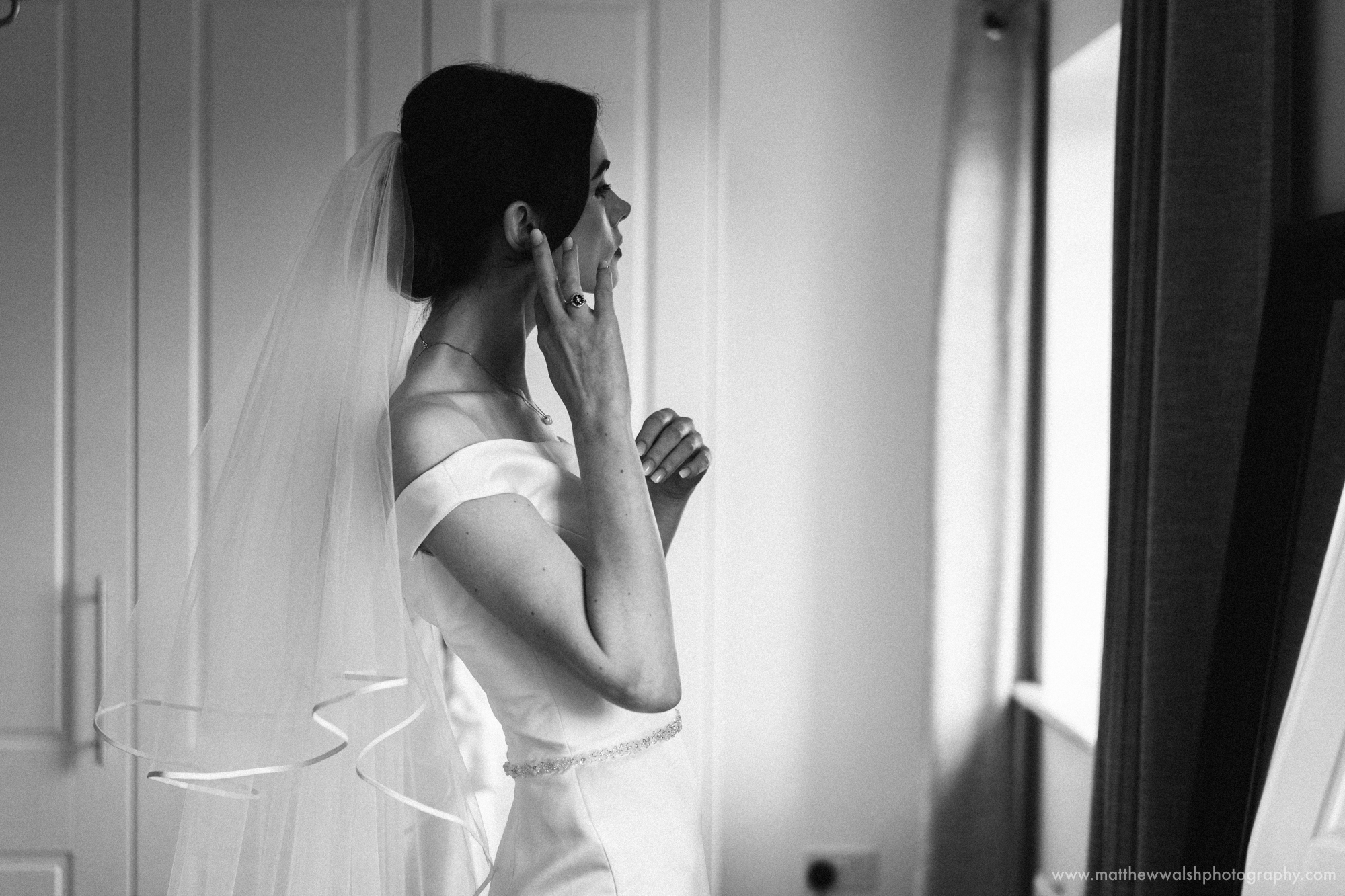 A simple fuss free image of the bride putting her earings in