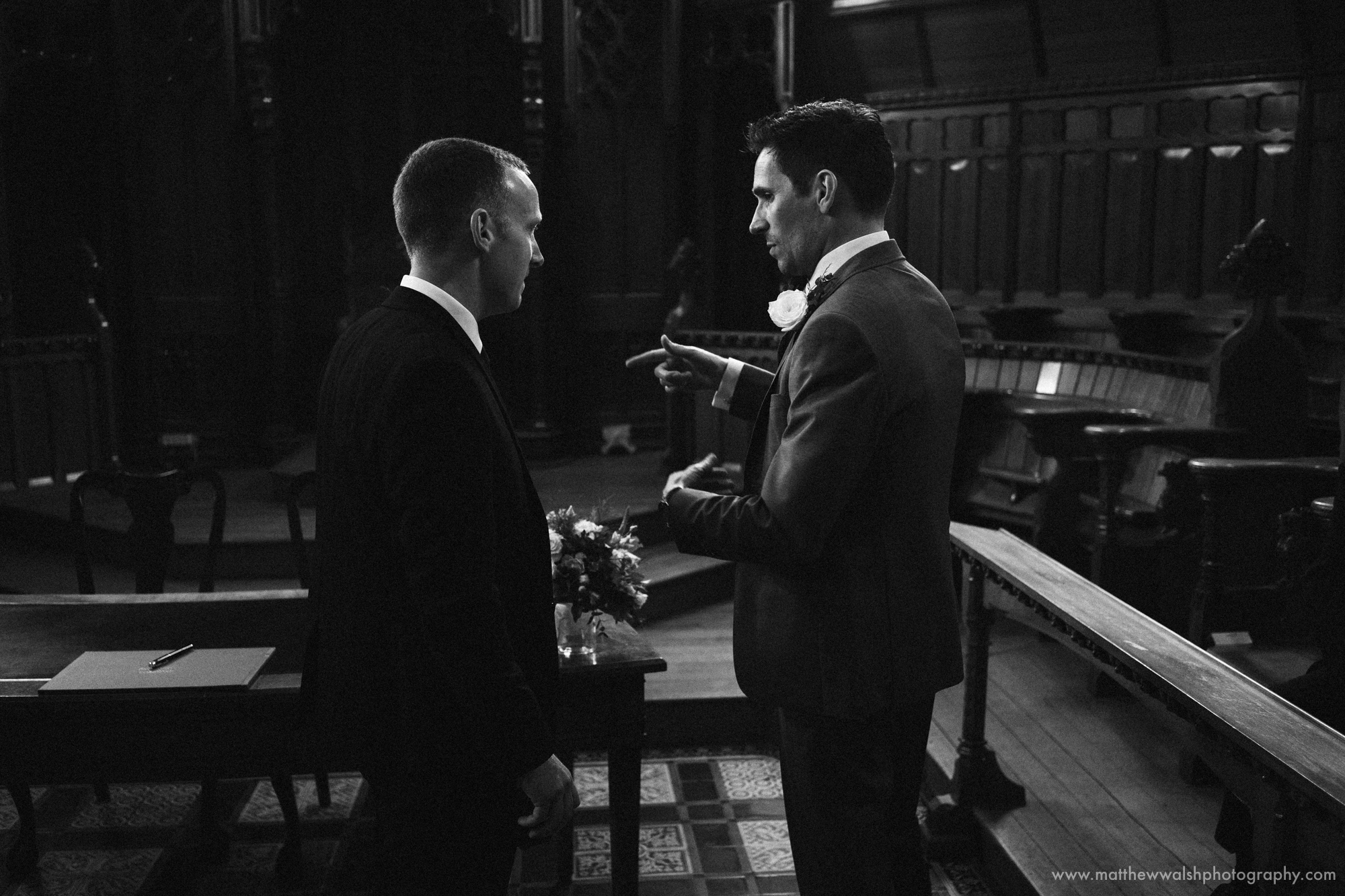 A dark reportage image of the Groom and Best man funning through there final details 