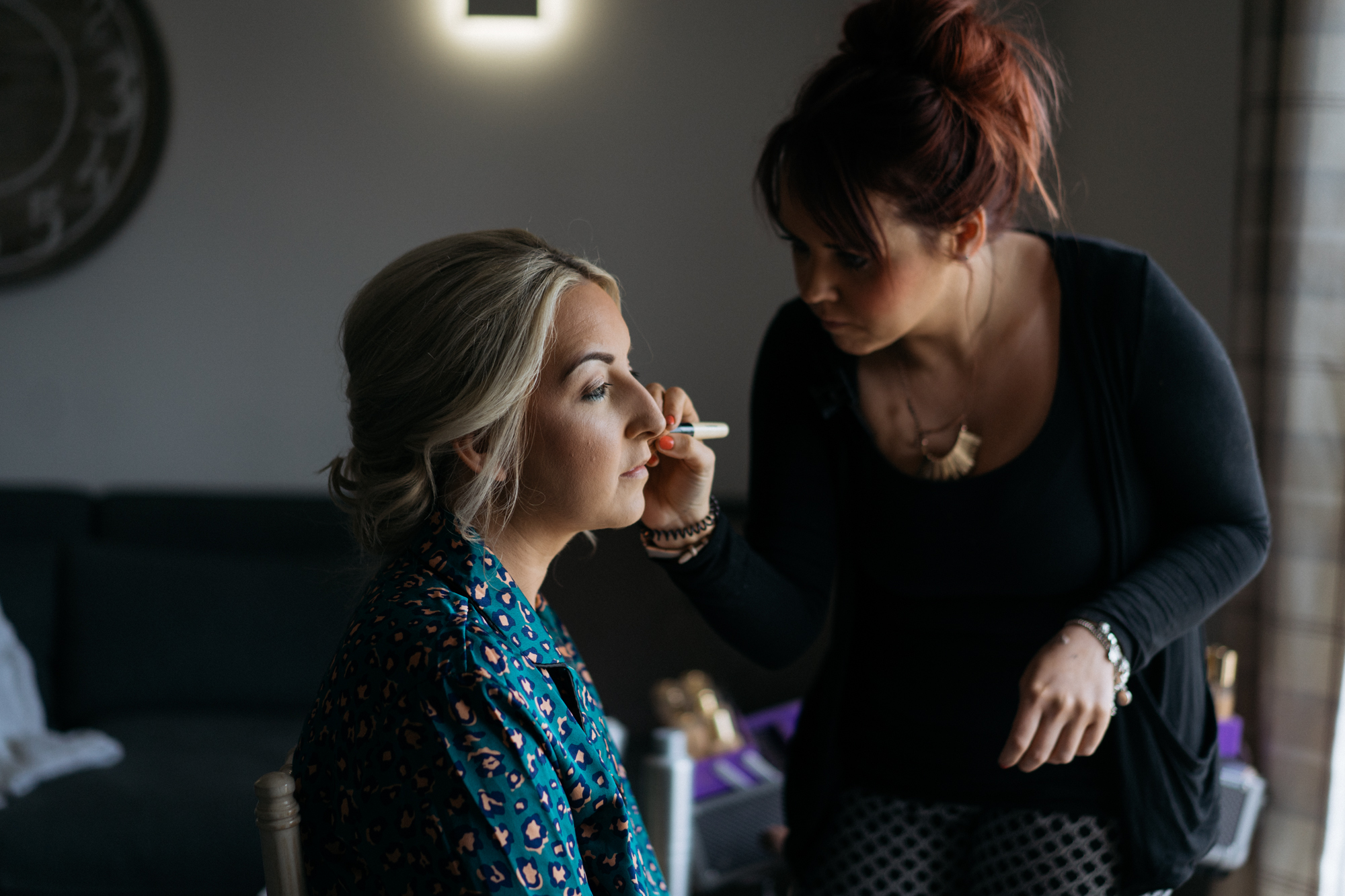 Colour image of the bride having her makeup done